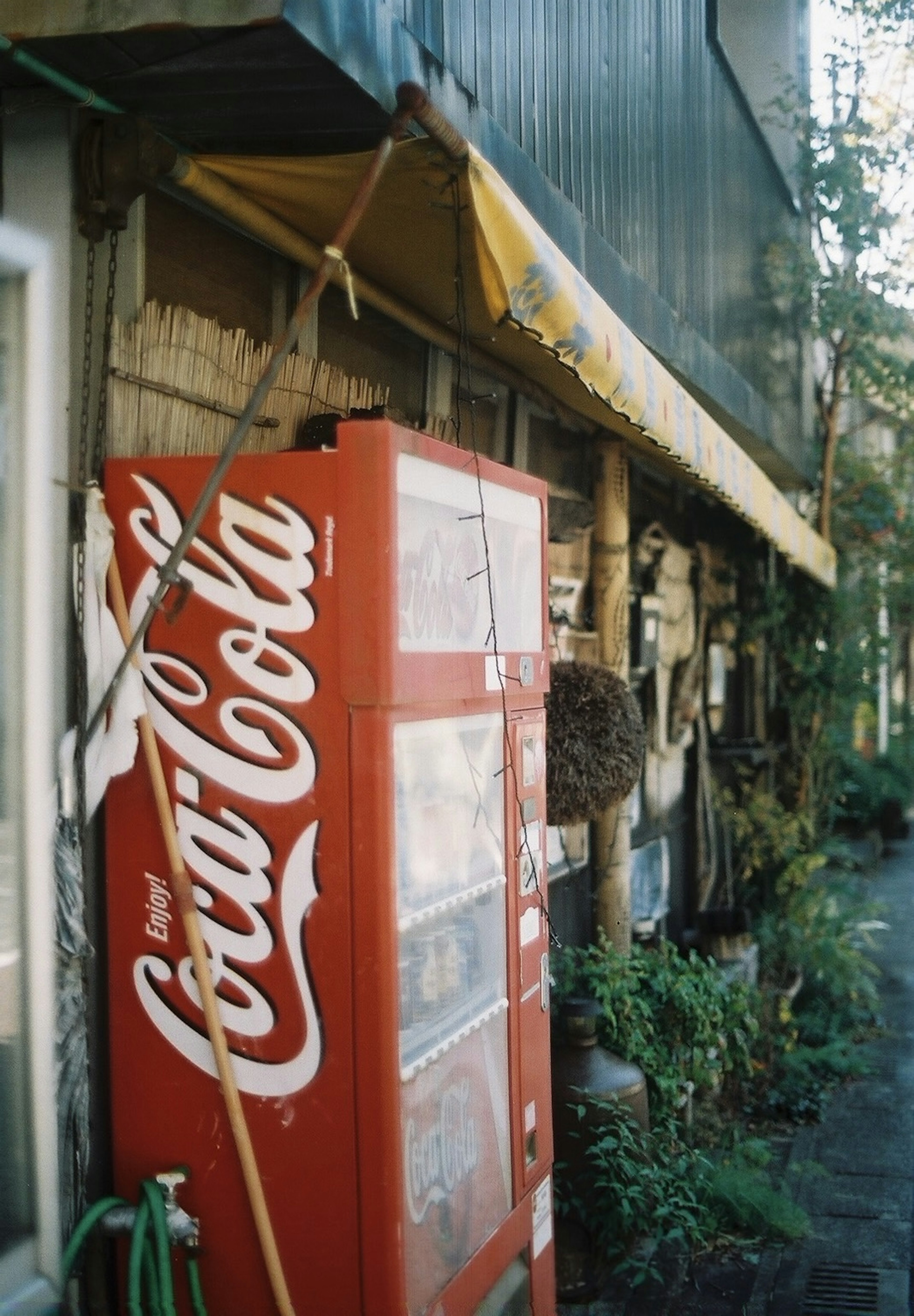 Bên ngoài tòa nhà cũ với máy bán hàng Coca-Cola màu đỏ