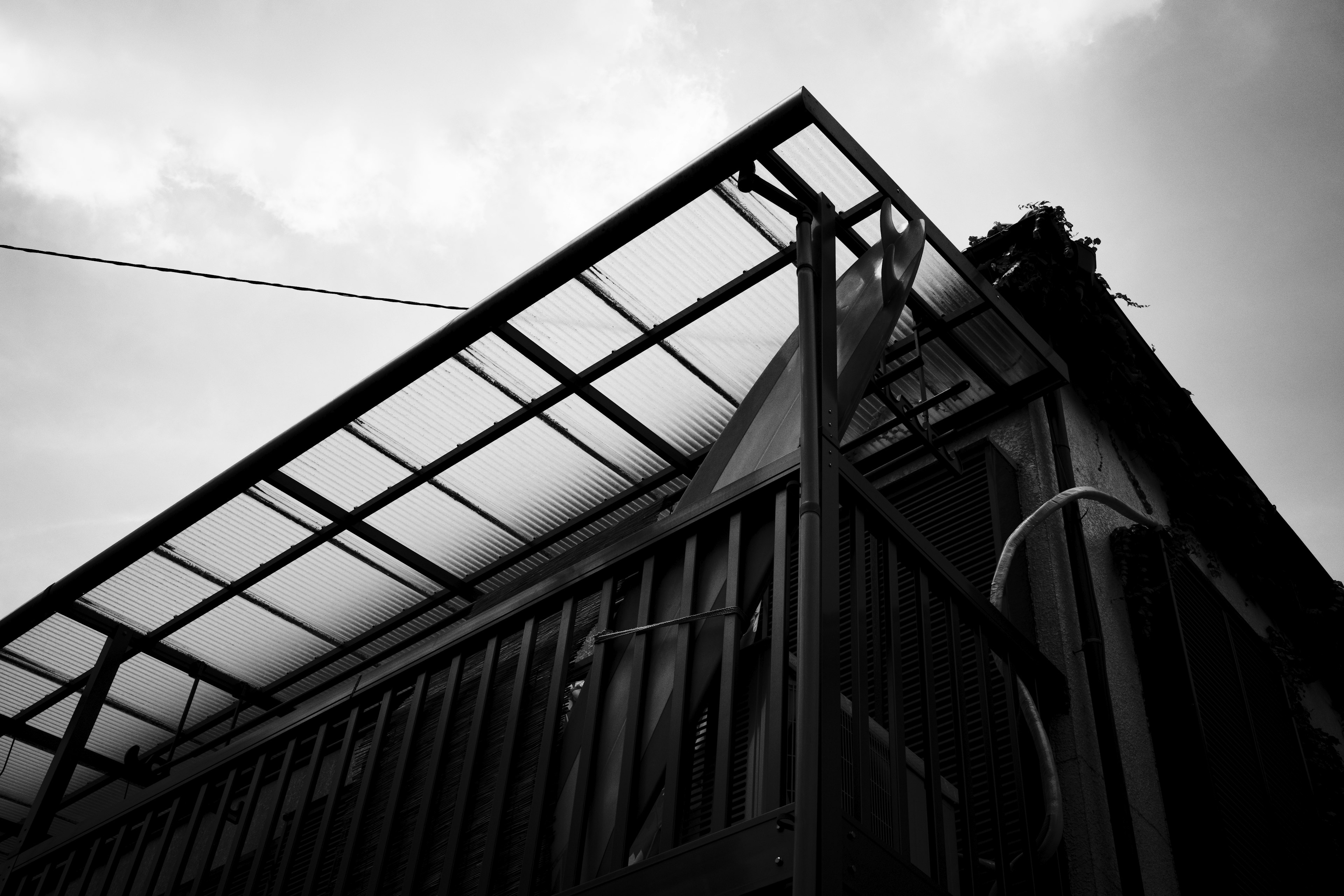 Photo of a building's corner featuring a black and white roof and structure