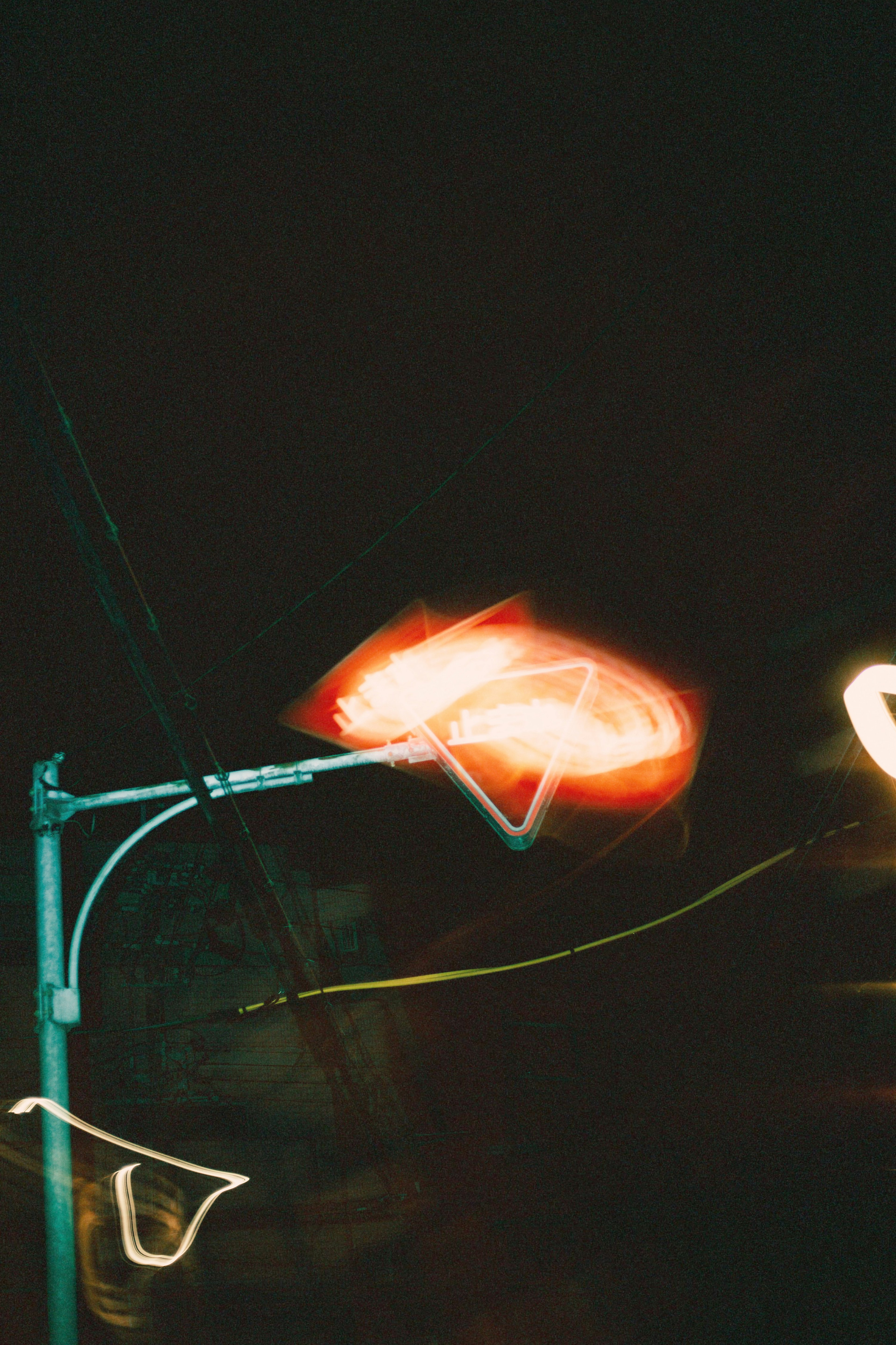 Foto einer Straßenlaterne mit verschwommenen Lichtspuren bei Nacht