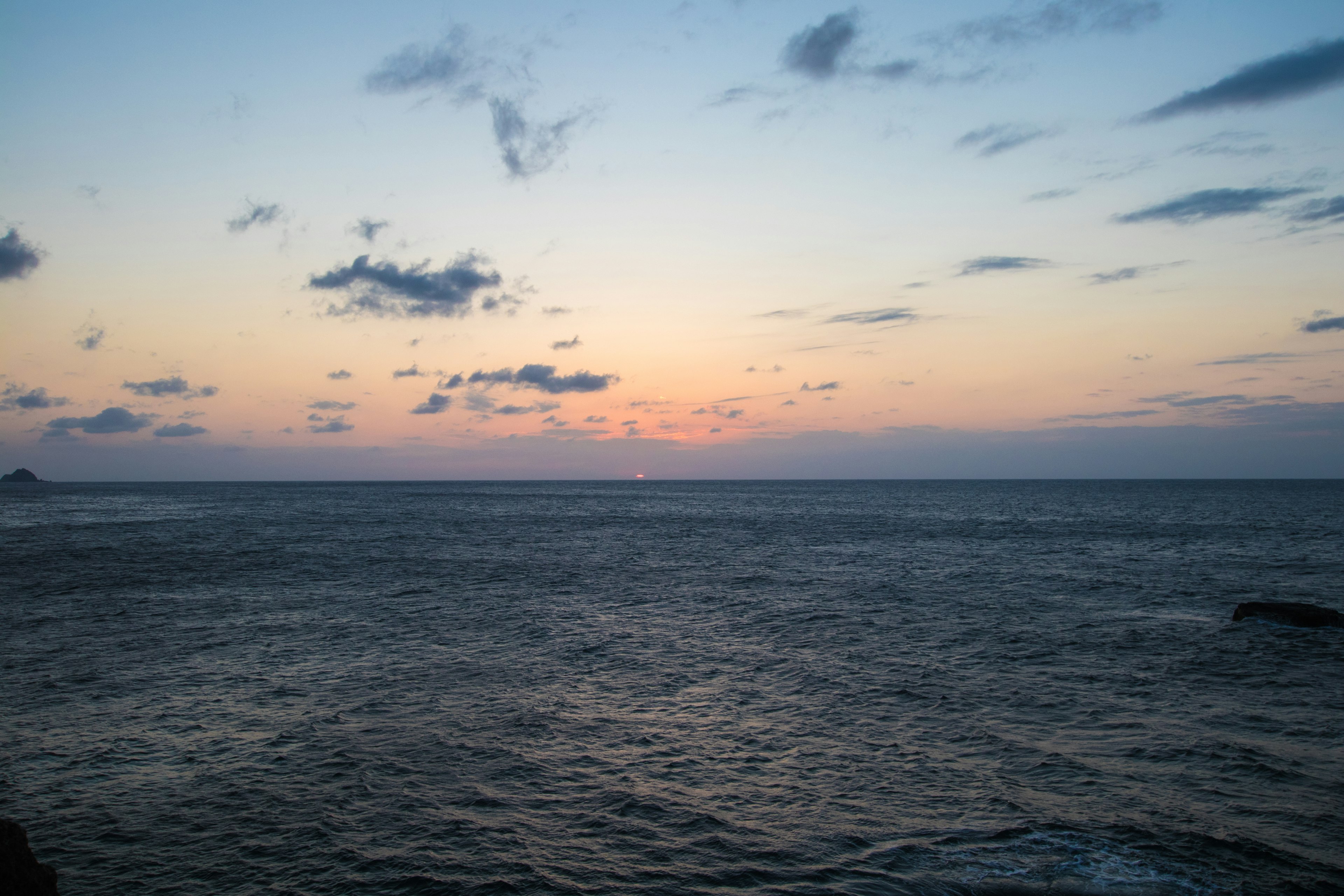 Vista panoramica dell'oceano al tramonto con nuvole colorate