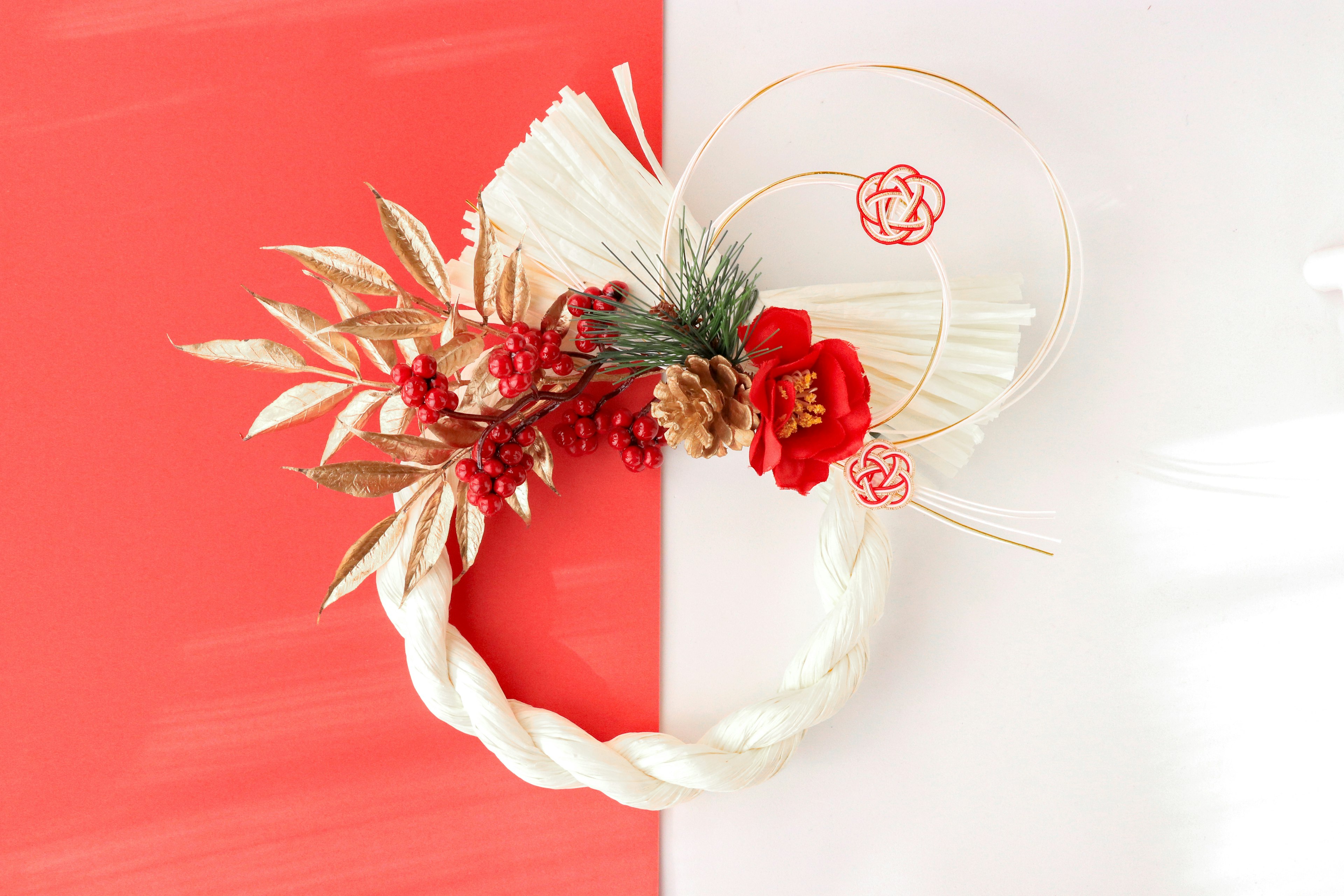 Beautiful floral wreath with golden leaves and red flowers against a red and white background