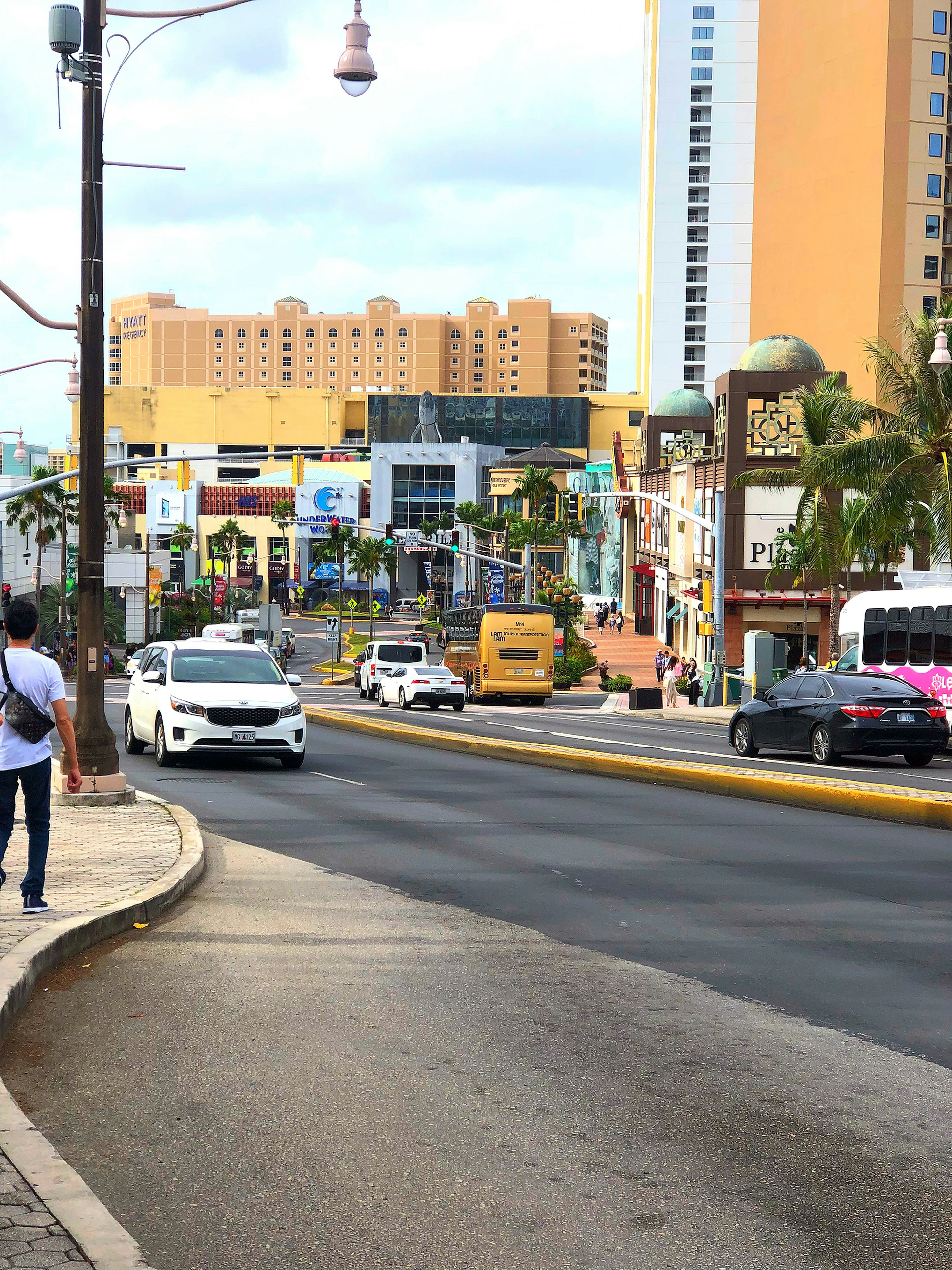 Vue de rue menant à une station balnéaire des Caraïbes avec des palmiers et des bâtiments