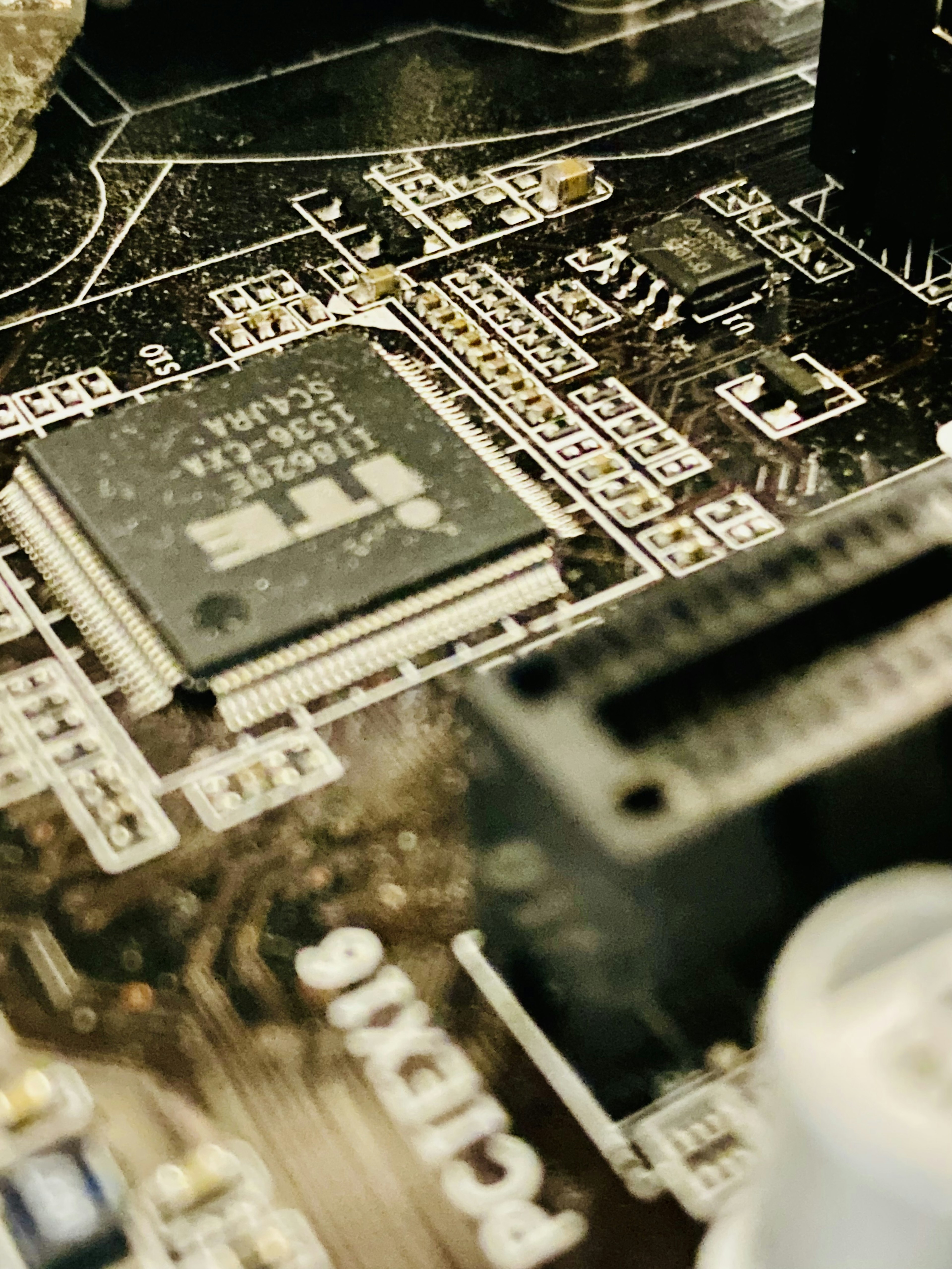 Close-up of an integrated circuit and connectors on a black circuit board