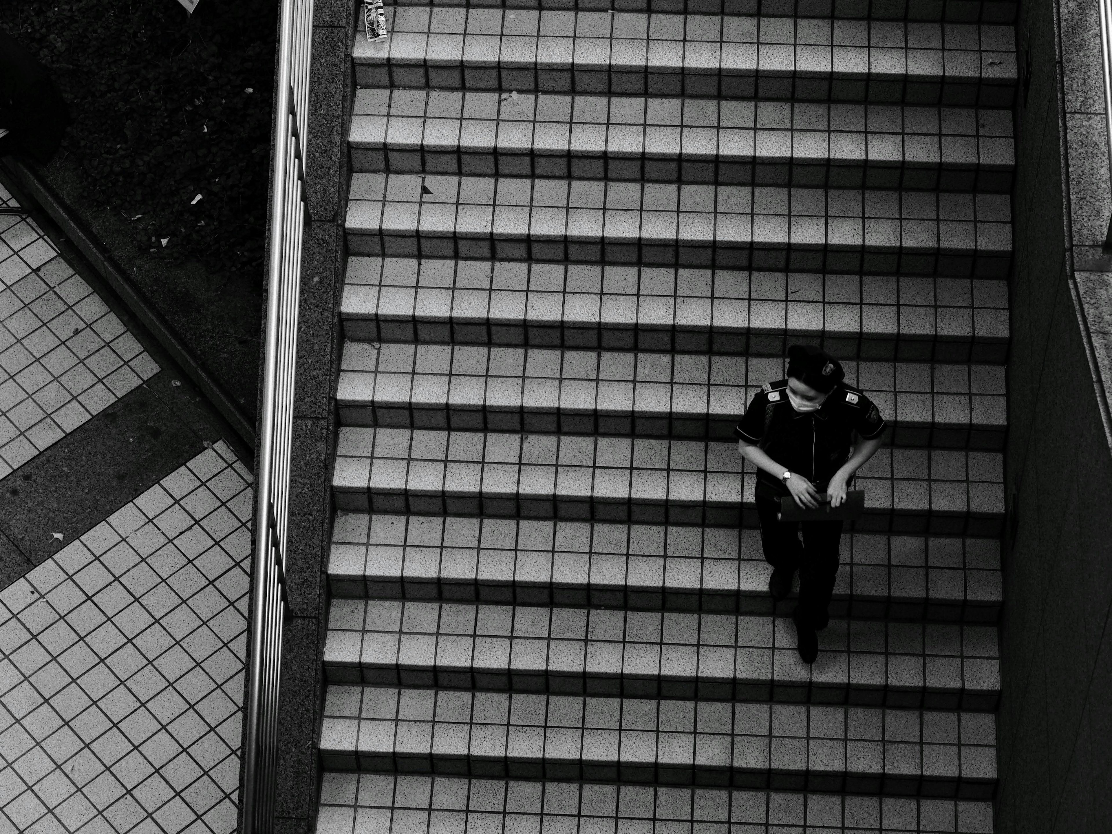 Black and white image of a person walking down stairs