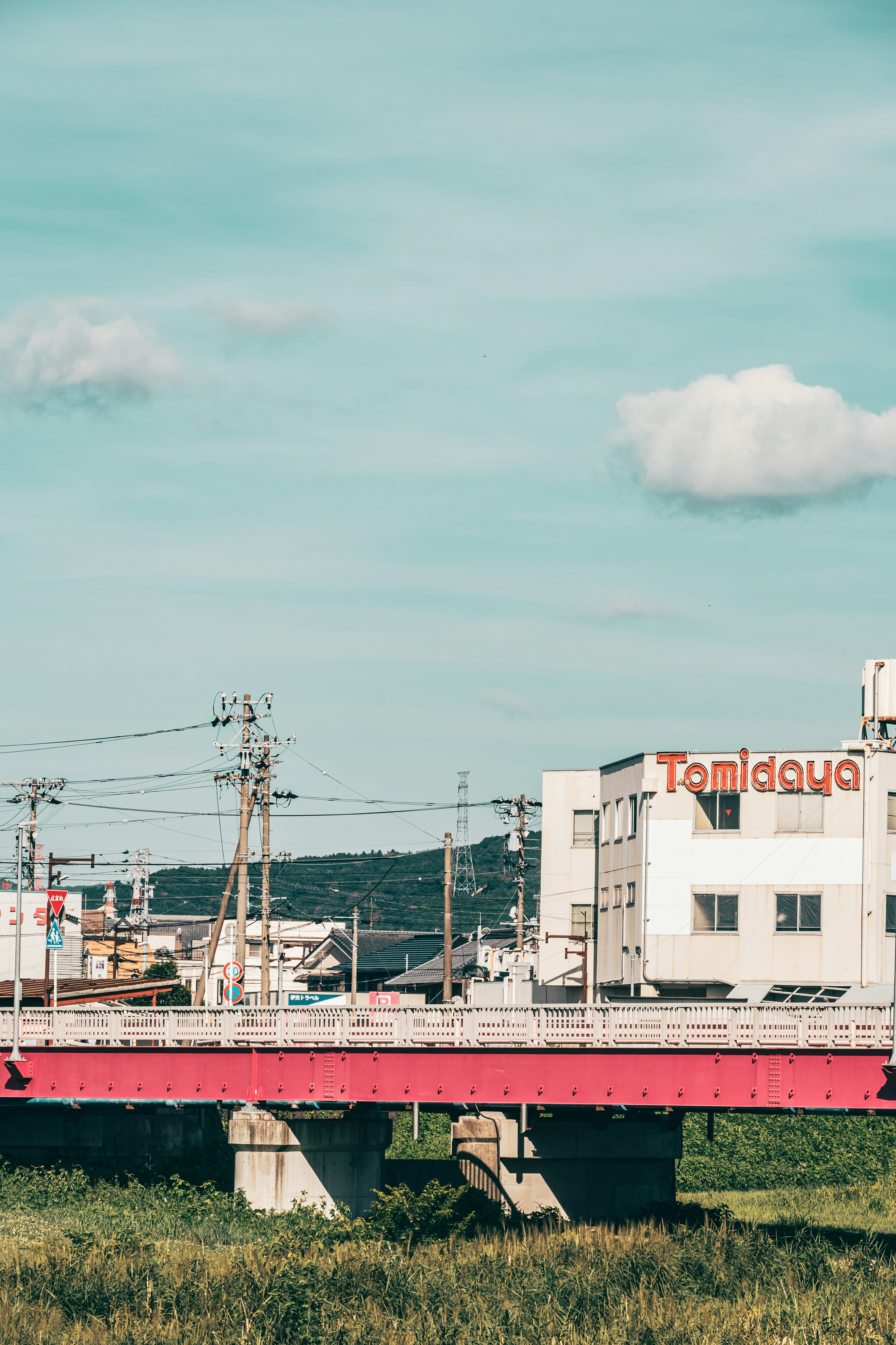 赤い橋と白い建物が見える田舎の風景