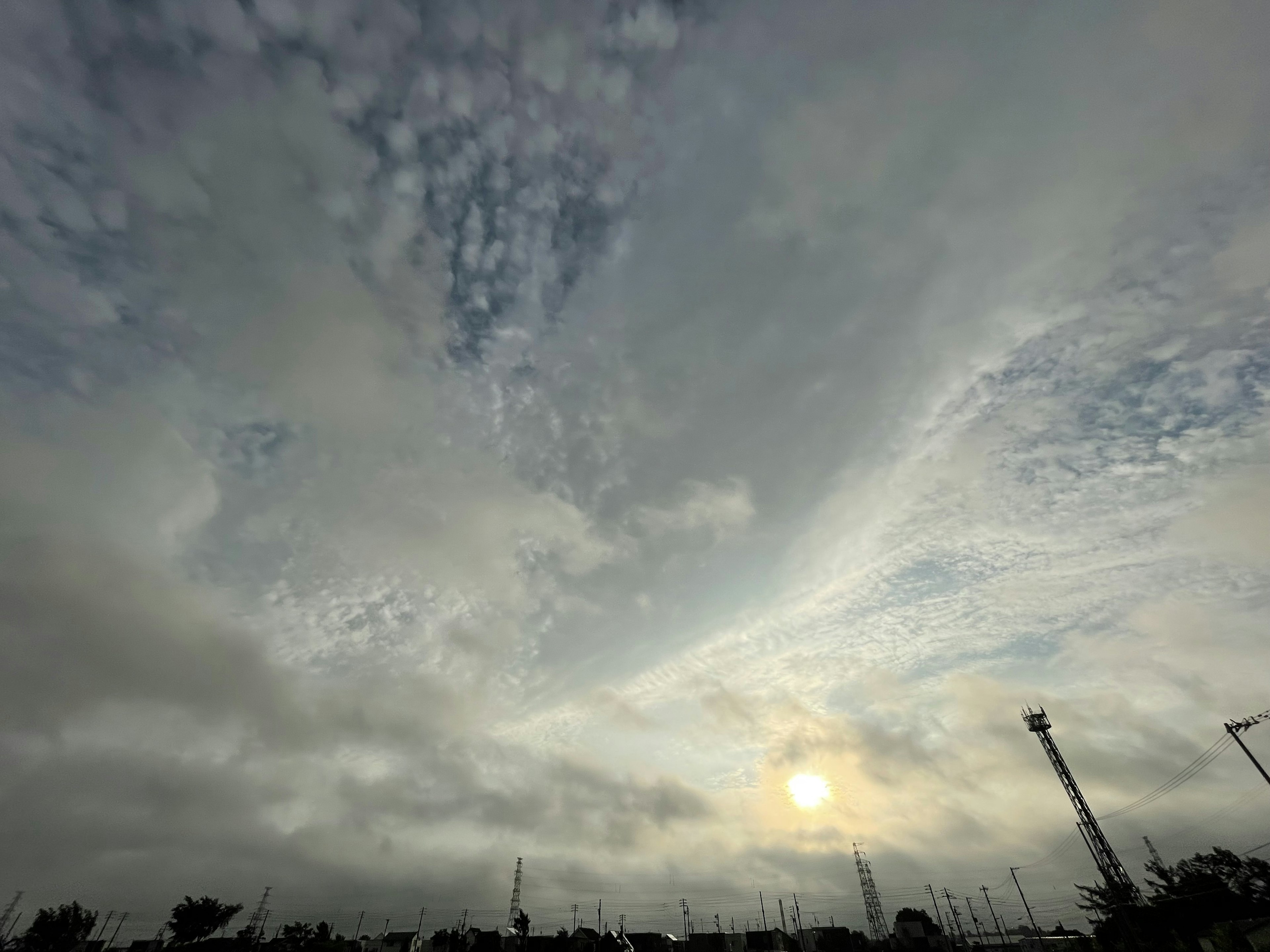 Cielo nublado con un sol poniente y nubes dispersas