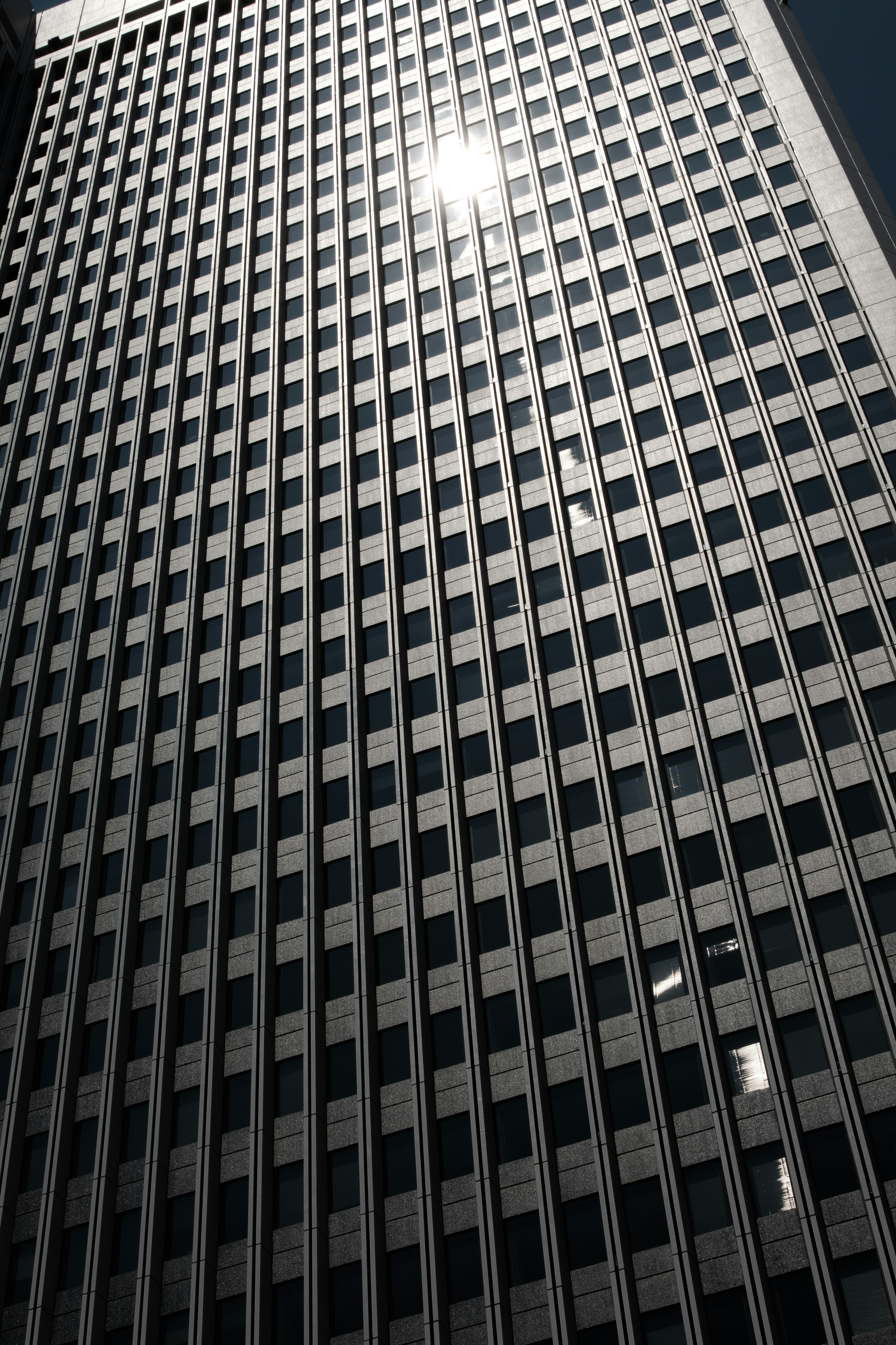 High-rise building with grid-patterned windows and reflective light