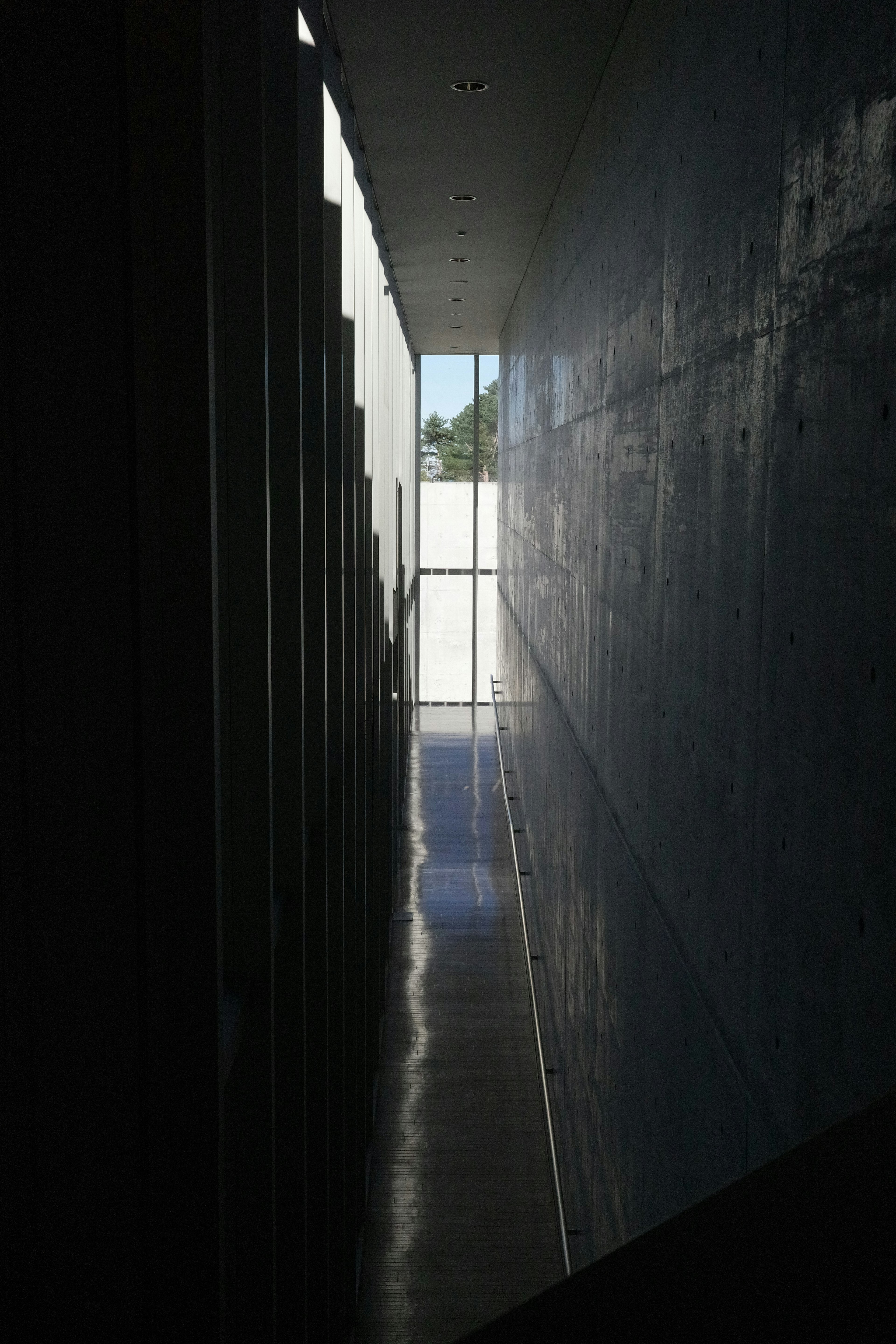 Narrow corridor with concrete walls and bright light streaming through