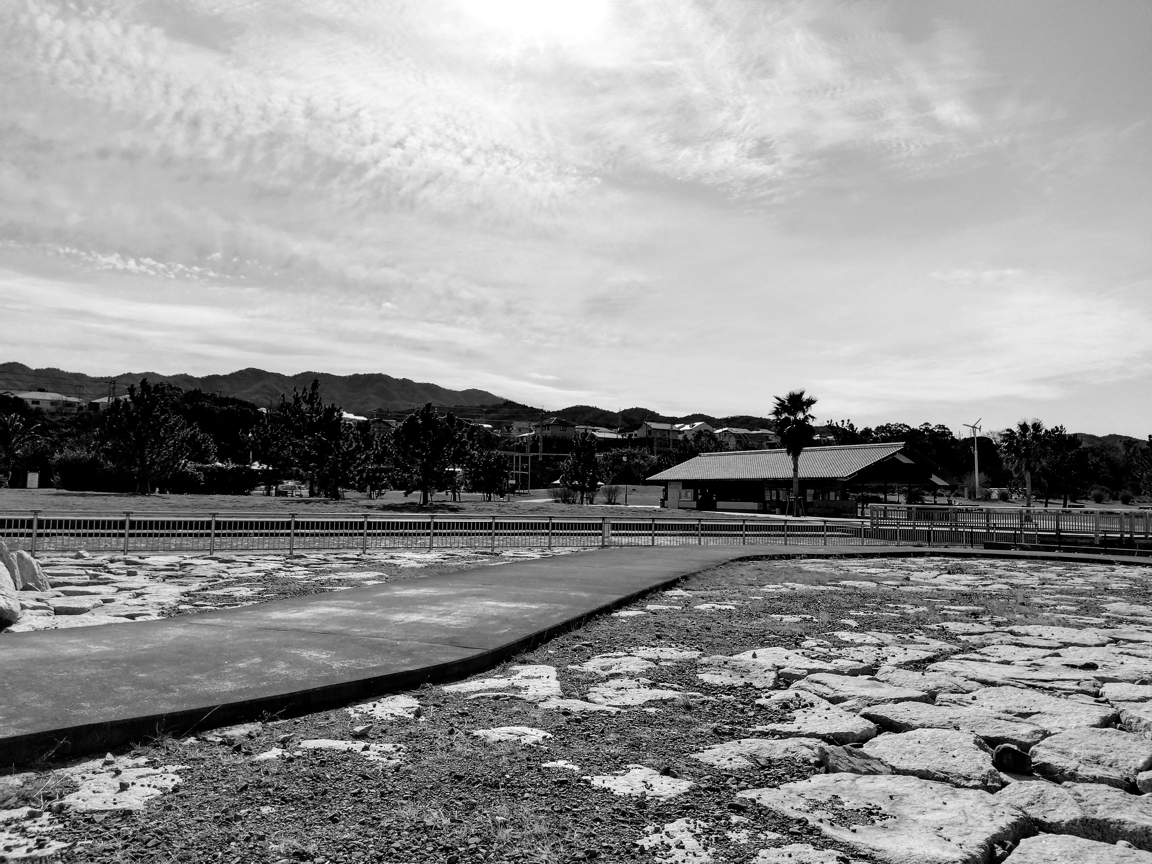 Black and white landscape featuring distant mountains and a building