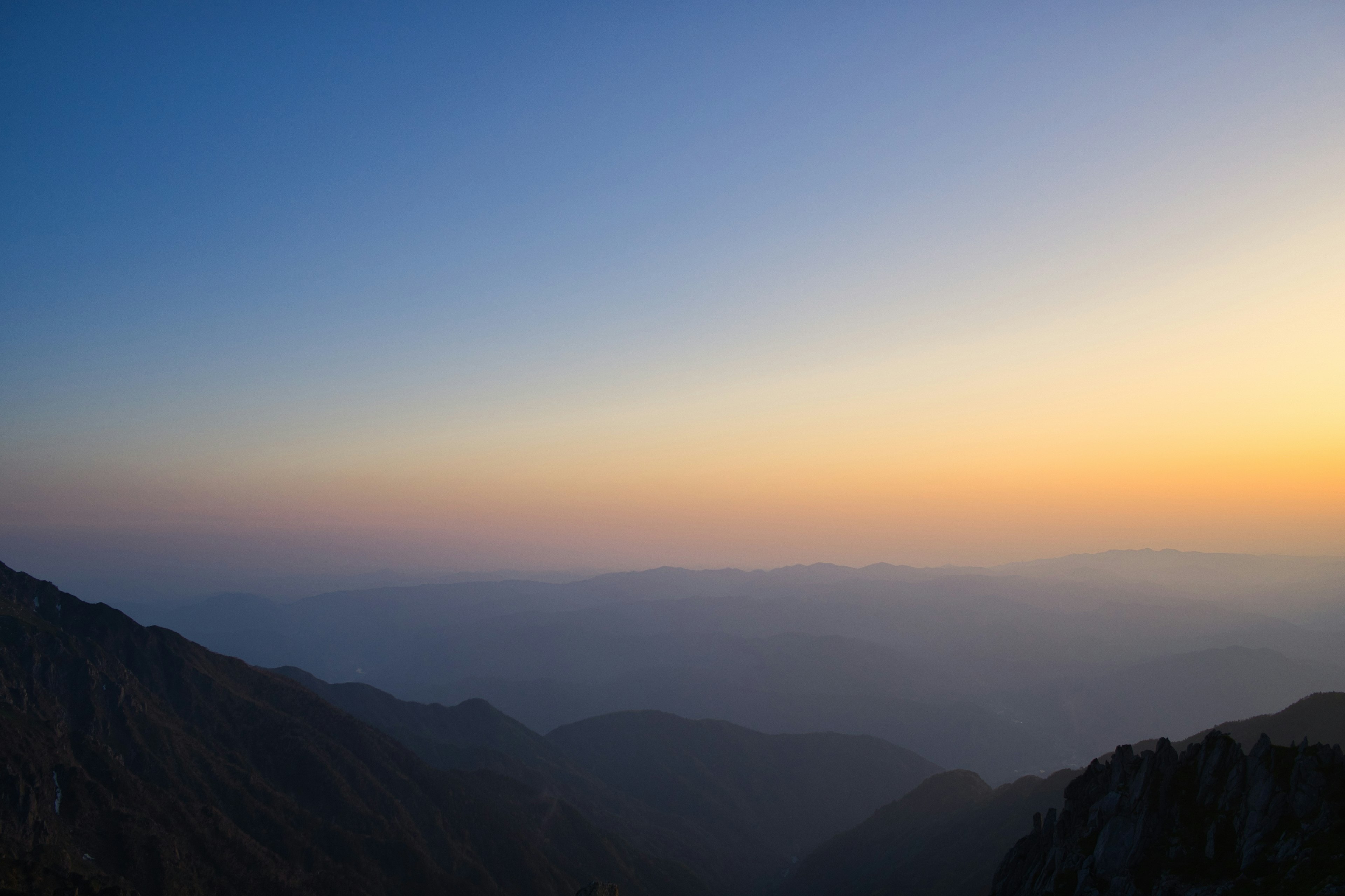 Vista escénica de montañas al atardecer con cielo degradado