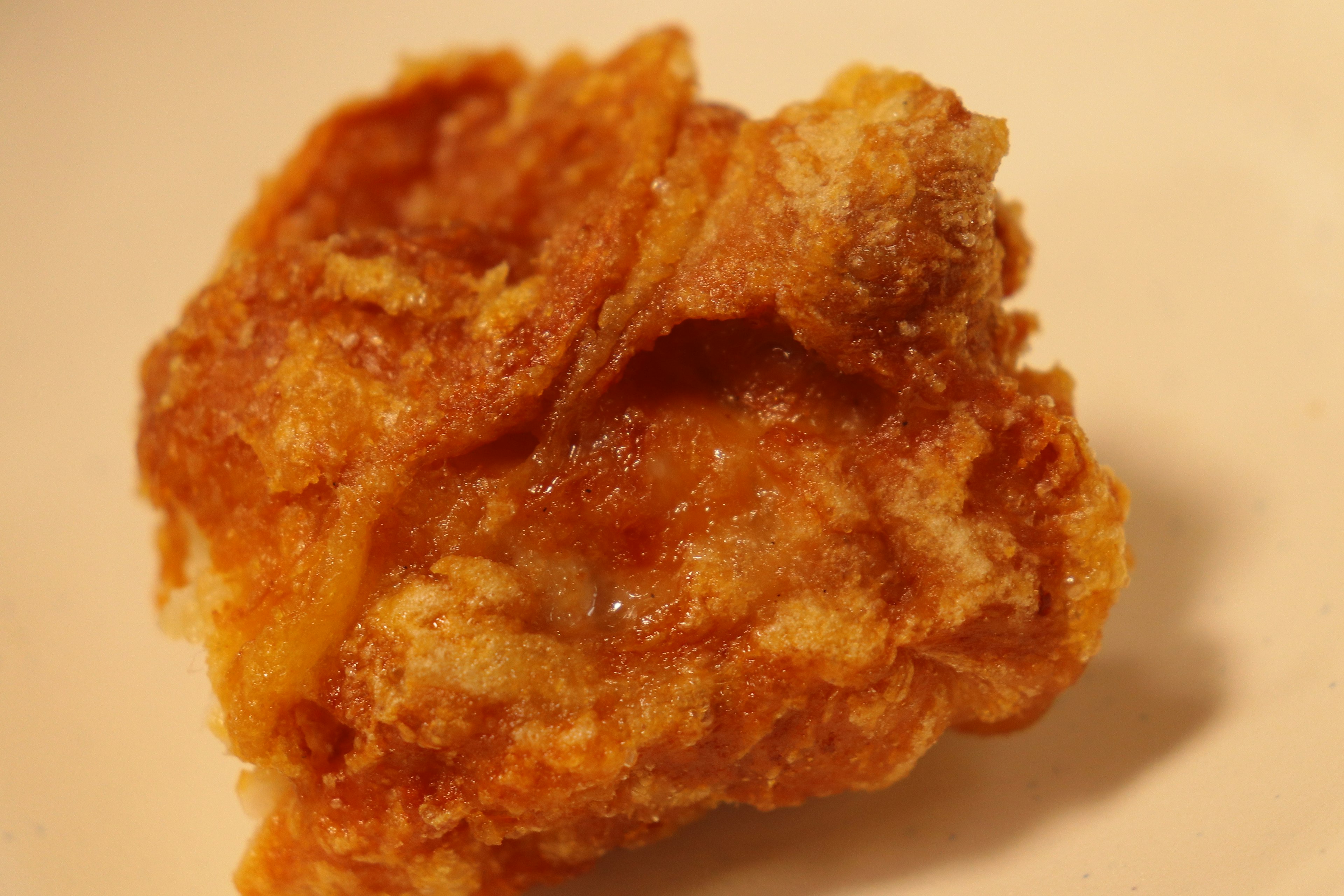 A piece of fried chicken with a crispy surface and golden appearance