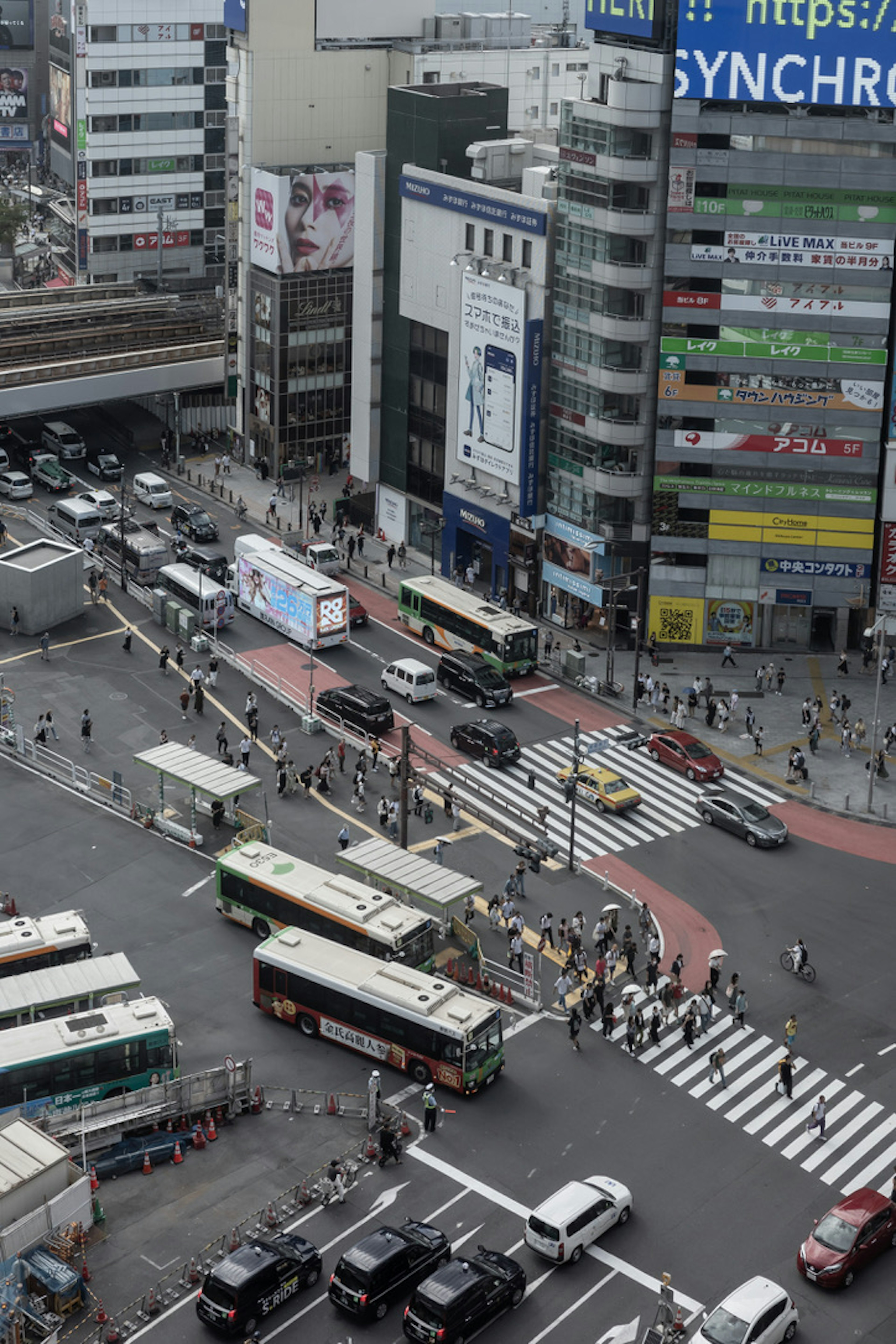 Paysage urbain avec des bâtiments de grande hauteur et un carrefour animé avec de nombreux véhicules et piétons