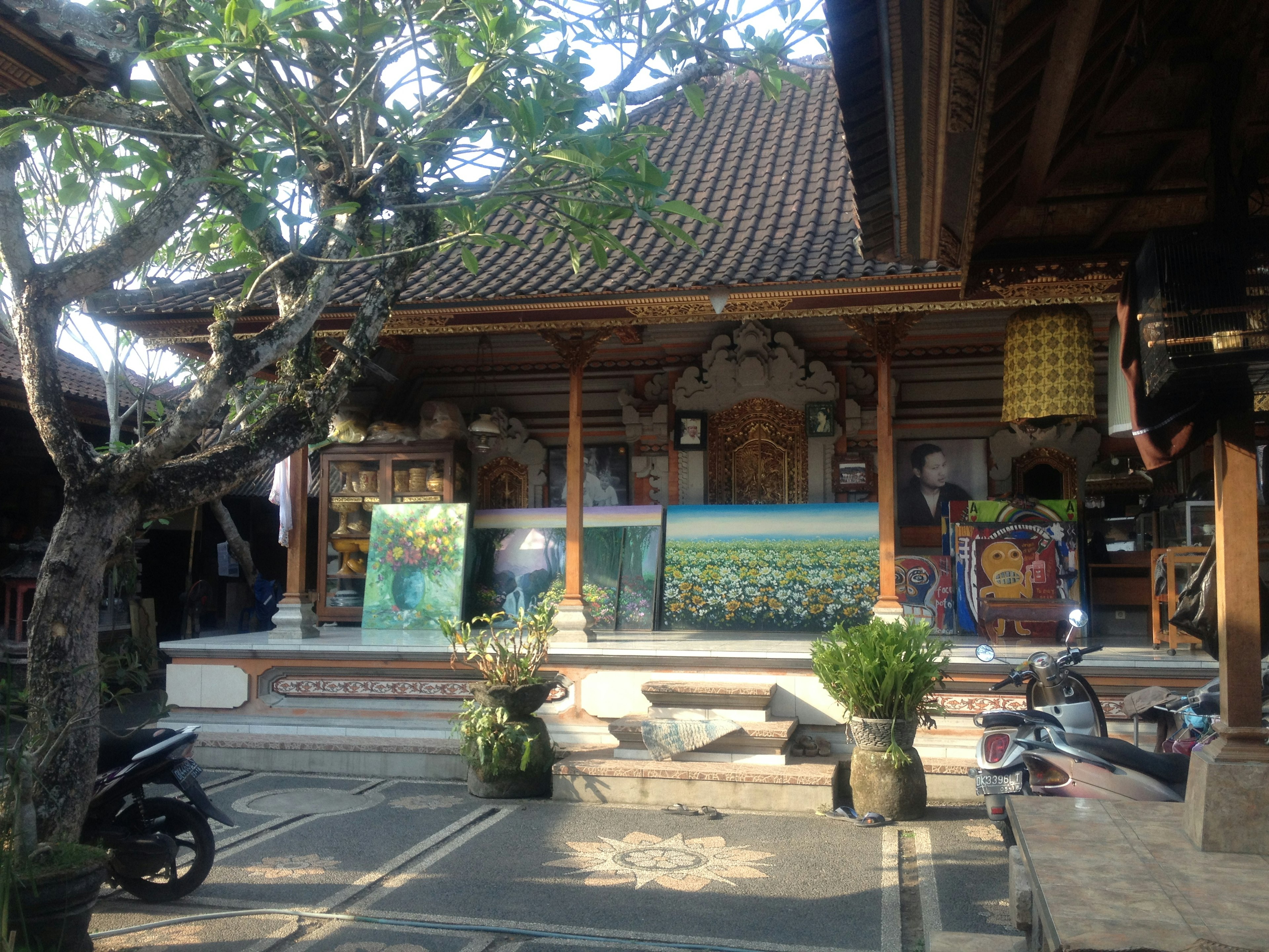 Traditional Balinese building with displayed art pieces and greenery