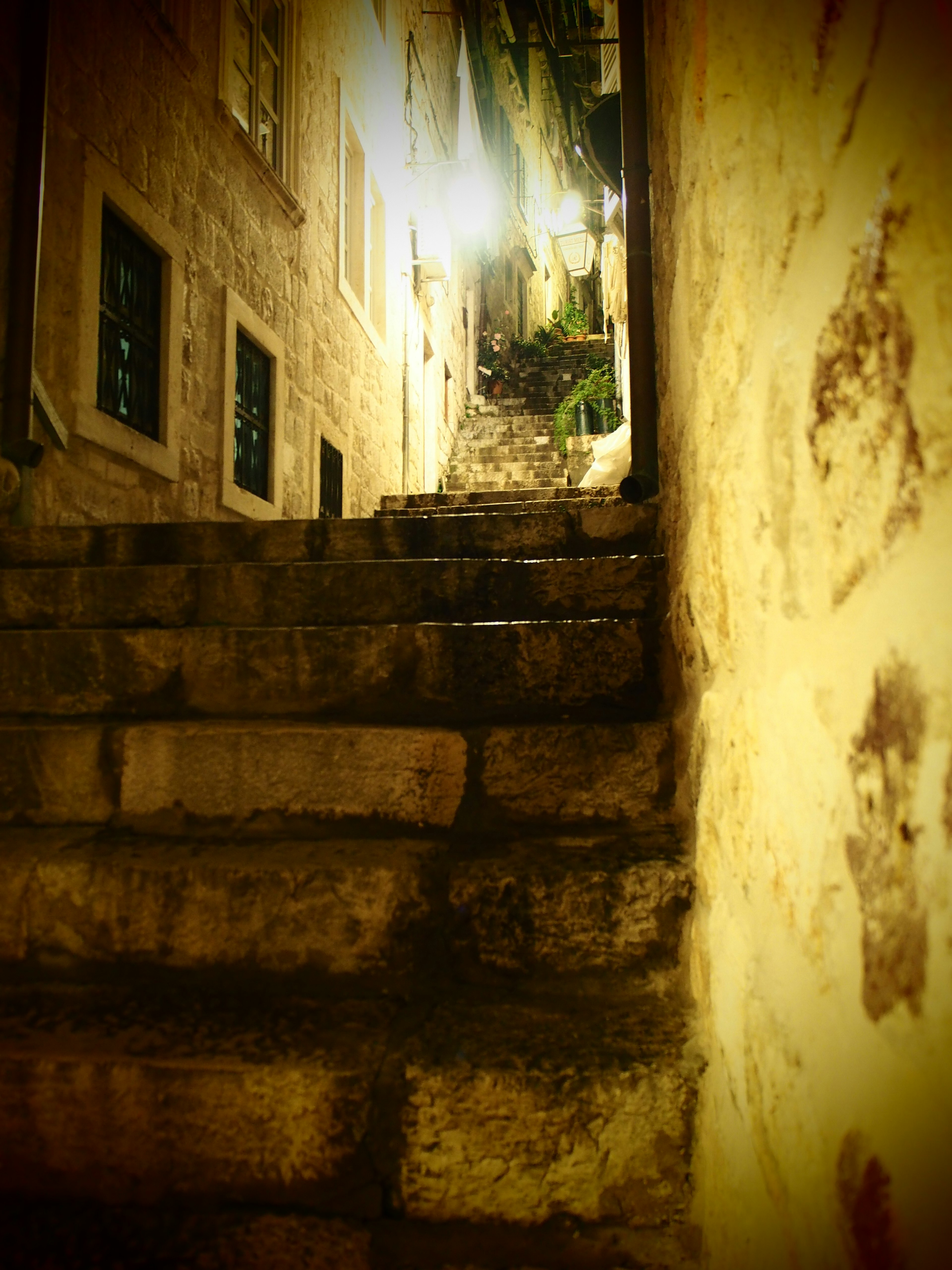 Antillas escaleras de piedra que conducen a un callejón débilmente iluminado