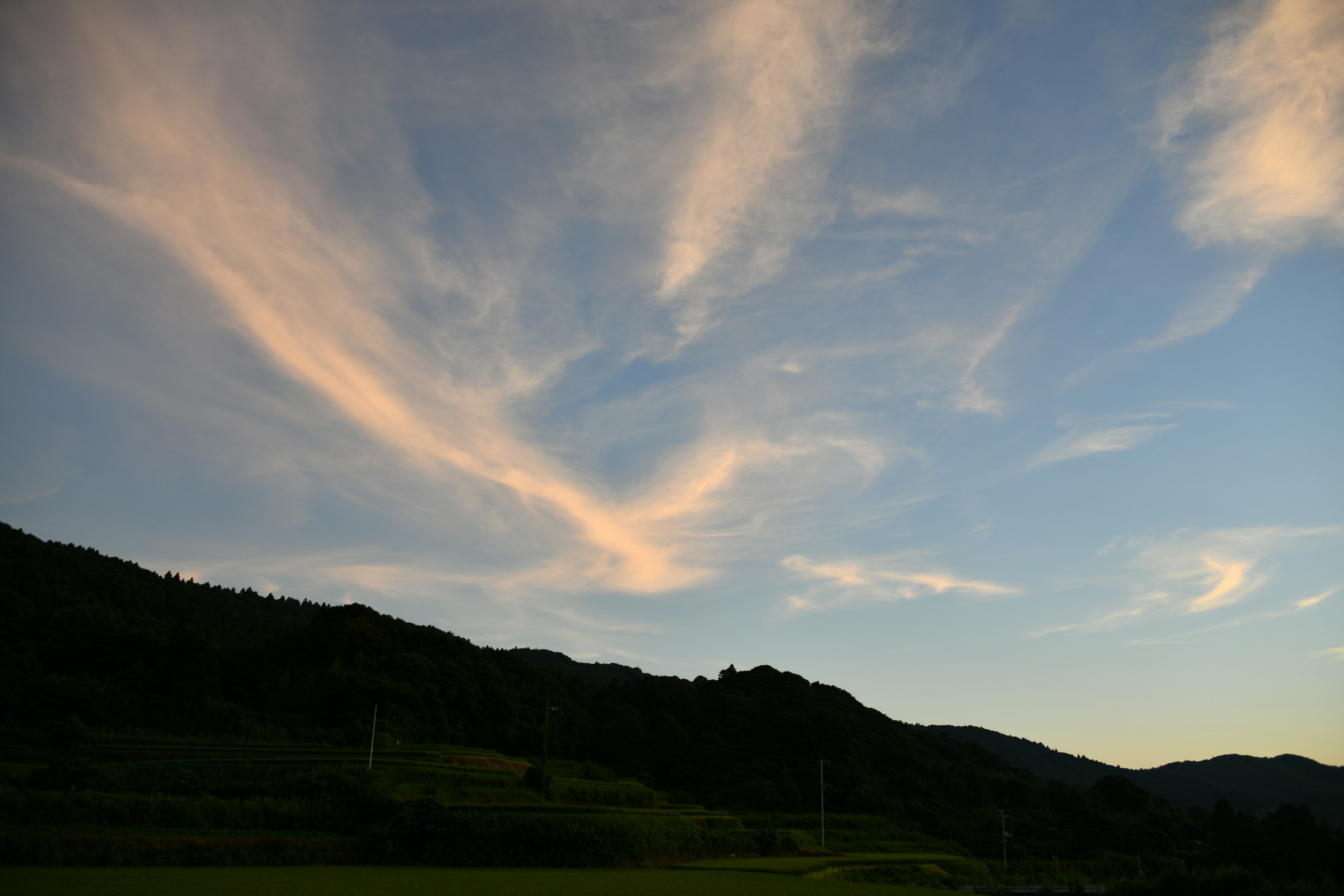 Nuages doux dans le ciel bleu avec des silhouettes de montagnes