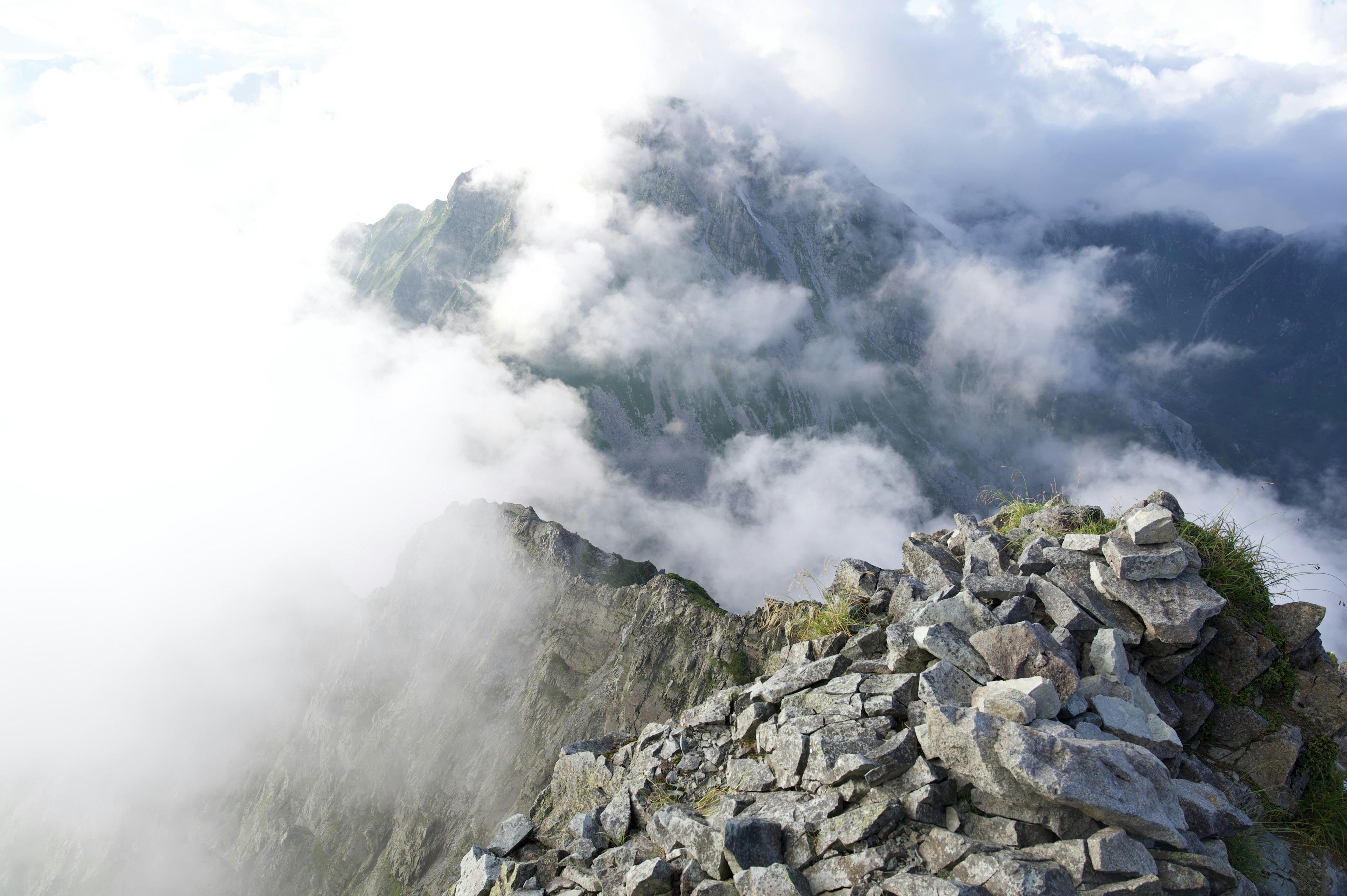 Vue depuis le sommet de la montagne enveloppé de nuages terrain rocheux et montagnes brumeuses