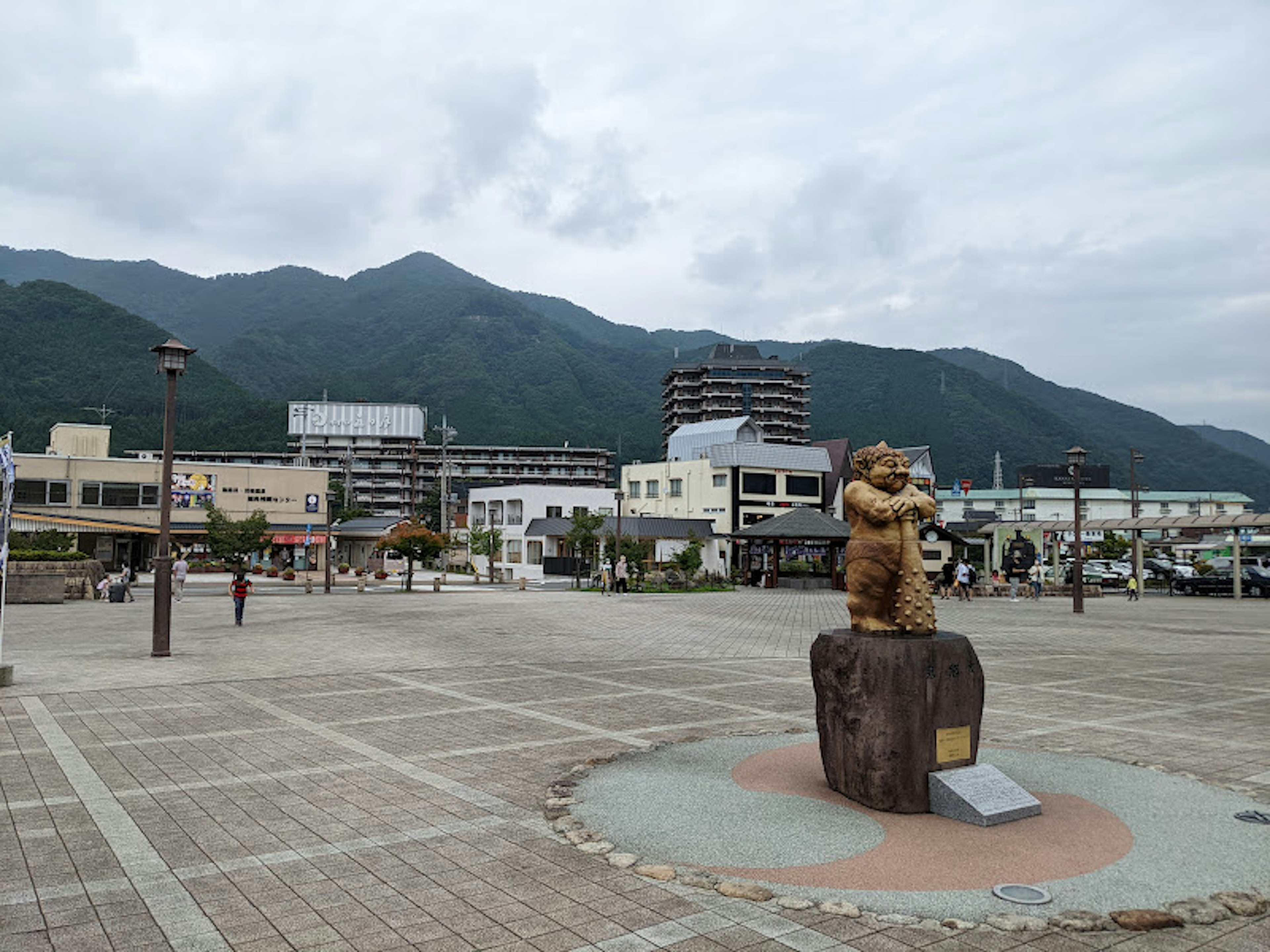 Eine Bärenstatue auf einem Platz mit Bergen im Hintergrund