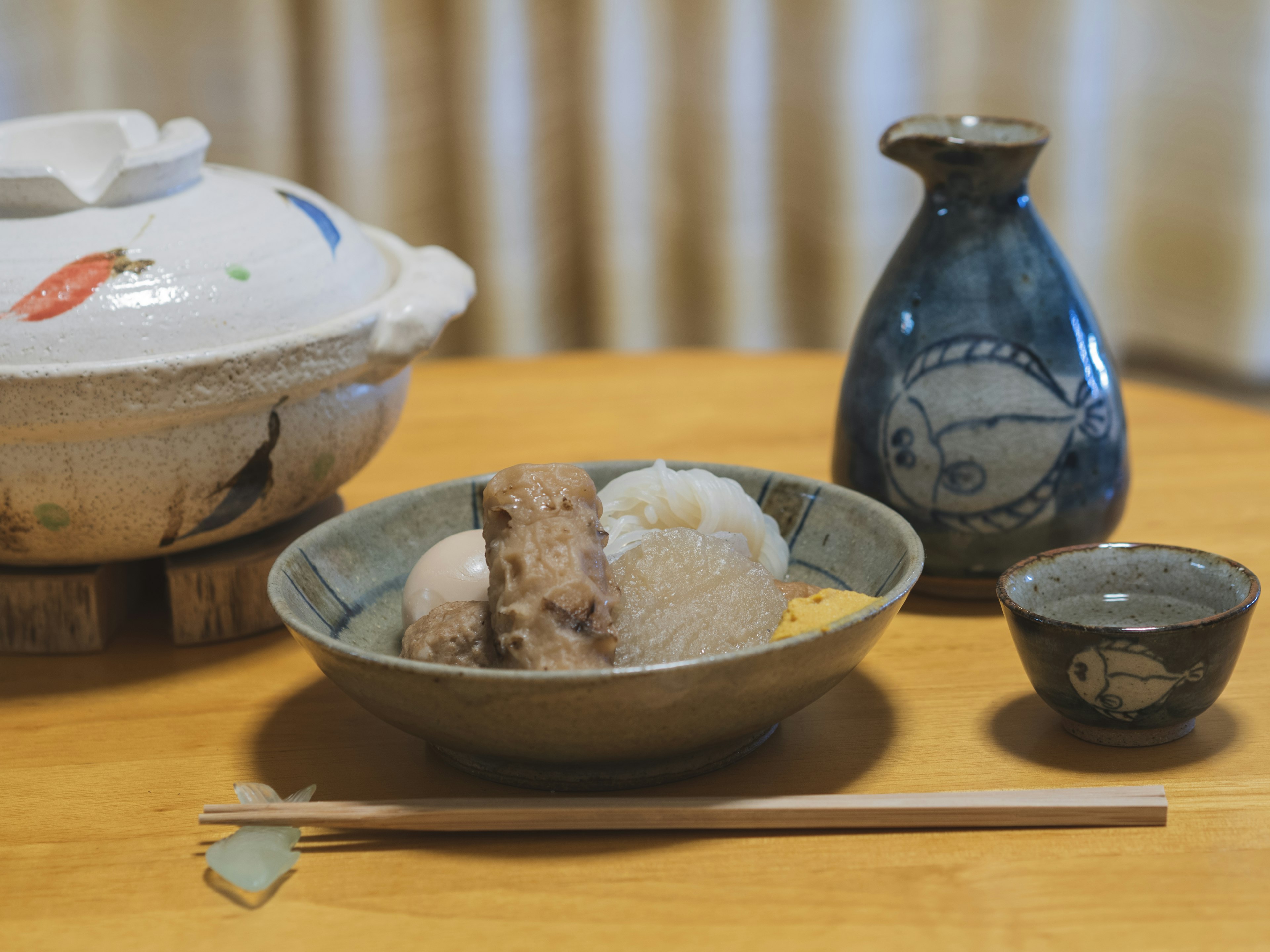 Bowl of rice and side dishes in Japanese tableware with sake bottle and small cup