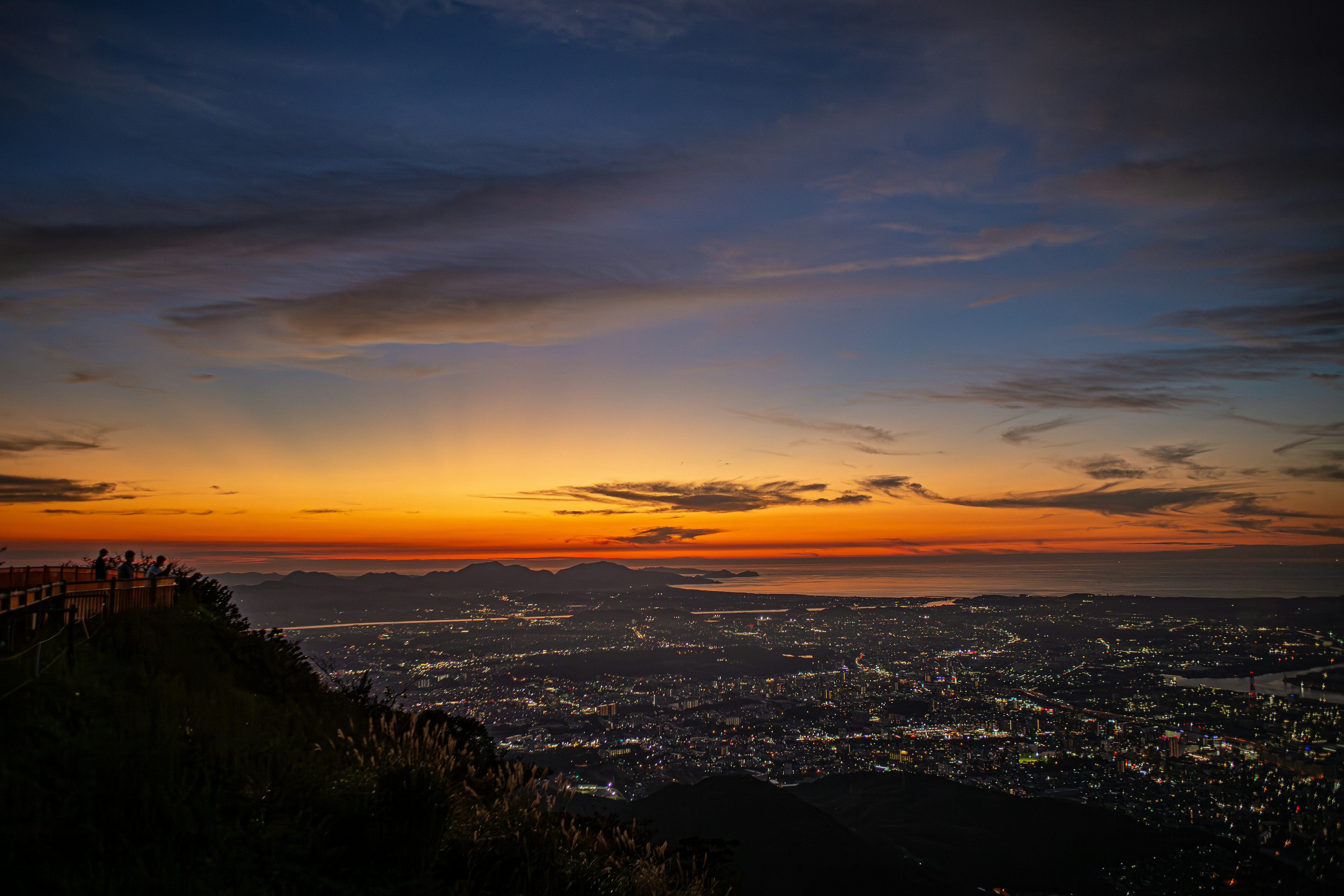 Hermosa vista del atardecer con luces de la ciudad desde una montaña