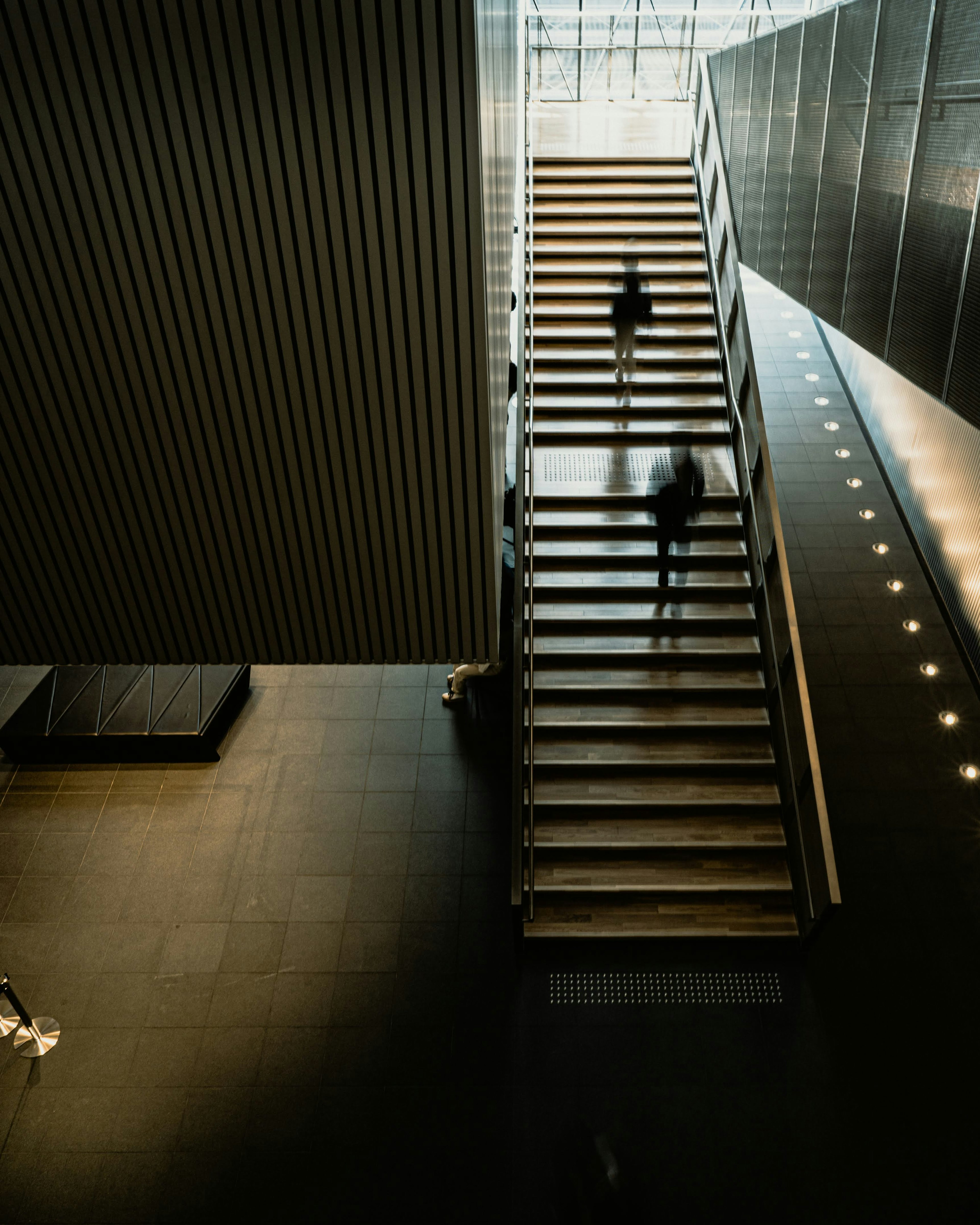 Interior de un edificio moderno con personas subiendo escaleras