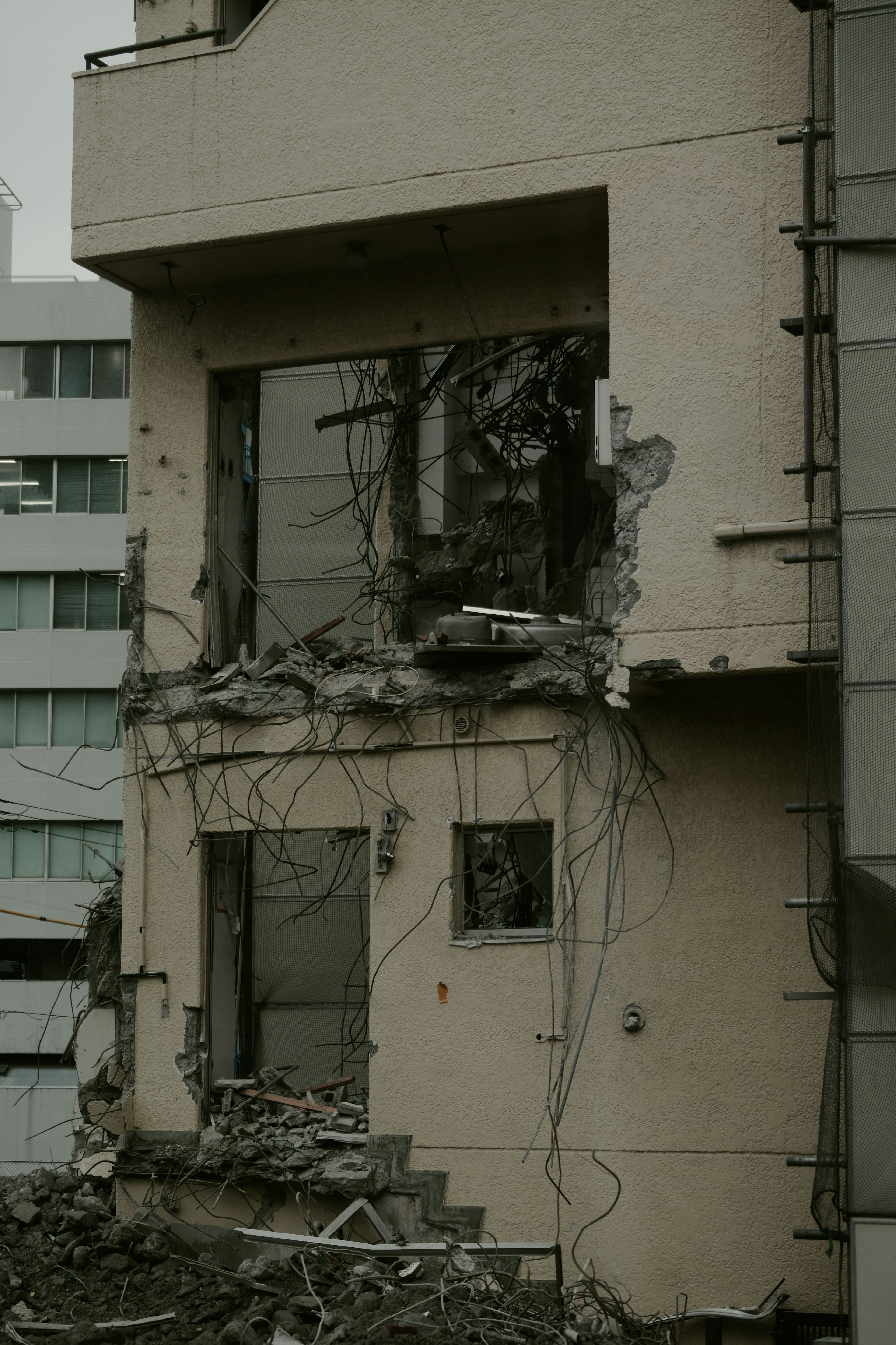 Esterno di un edificio danneggiato con muri crollati e cablaggi esposti