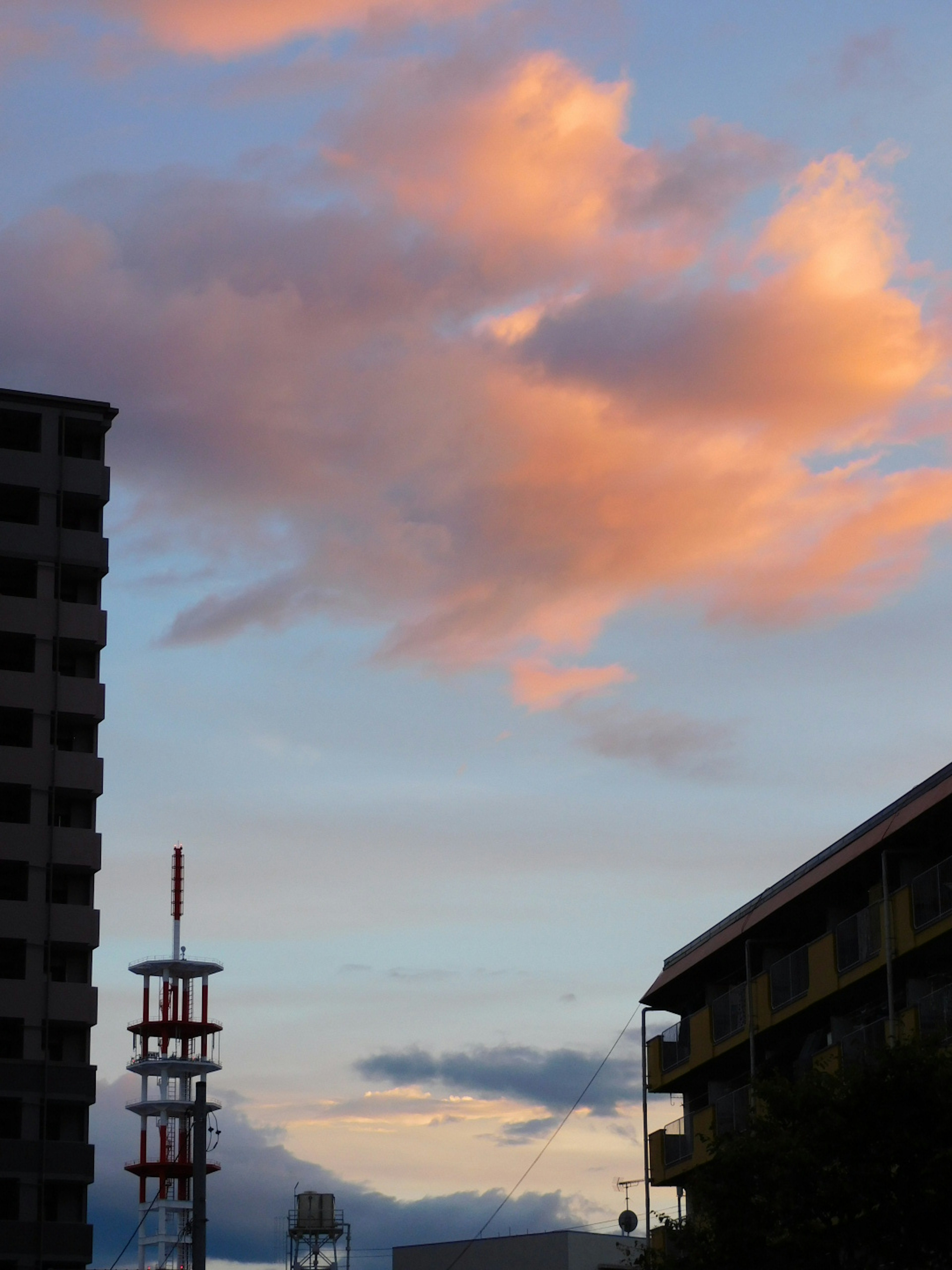 Nubes iluminadas por los colores del atardecer con edificios