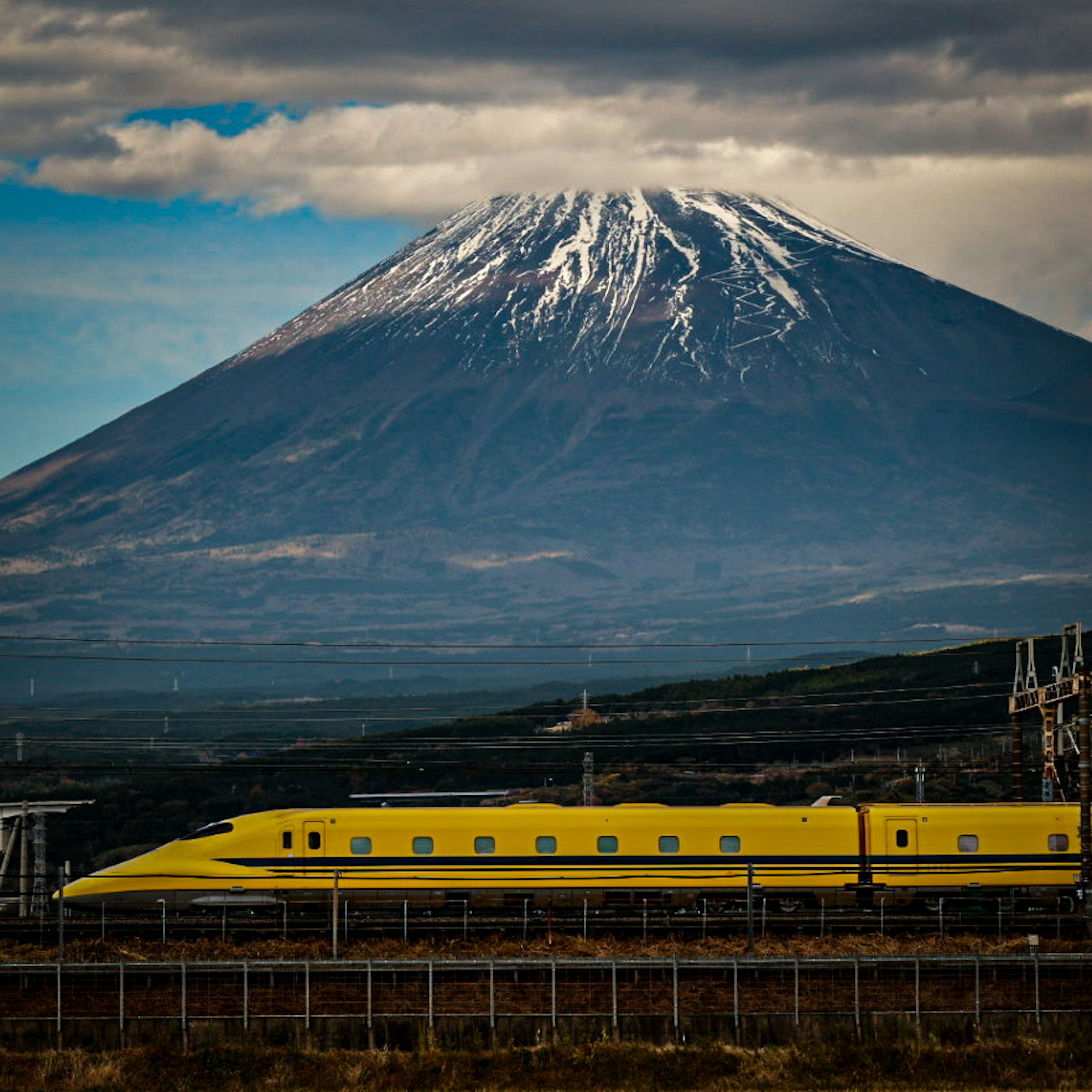 富士山を背景にした黄色い新幹線の画像