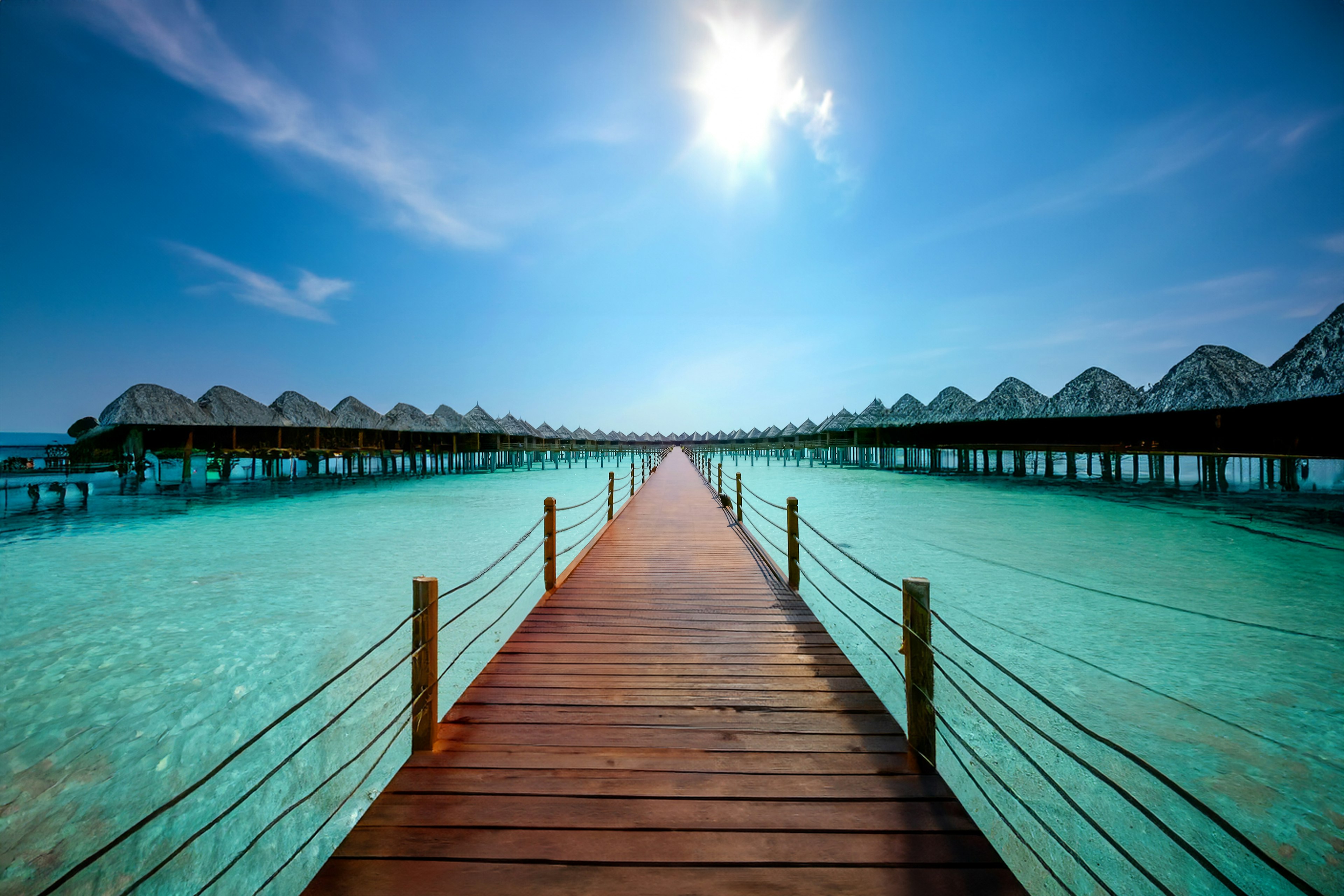 Pemandangan indah dengan dermaga kayu di atas air berwarna turquoise