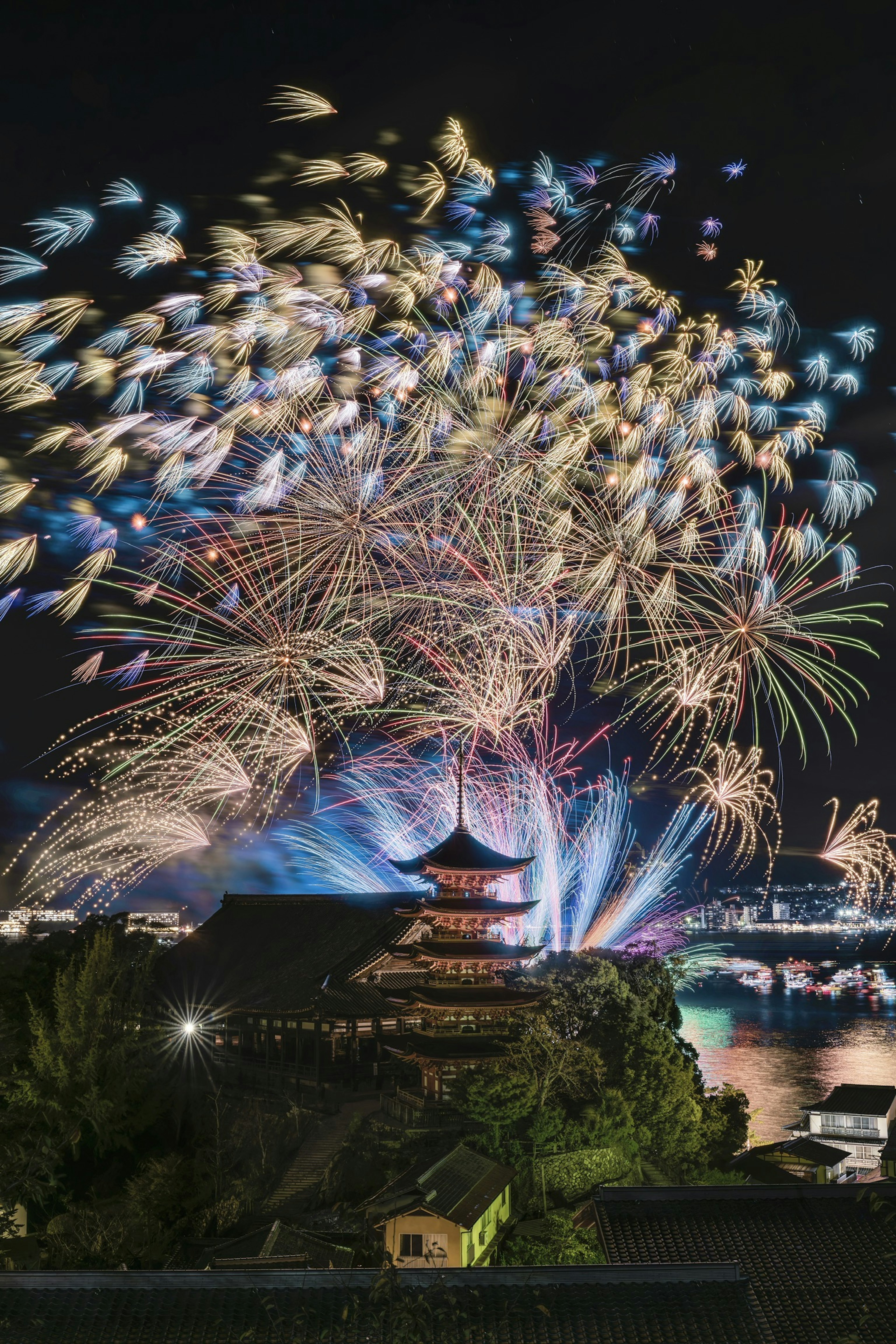 I fuochi d'artificio illuminano il cielo notturno sopra una pagoda a Kyoto