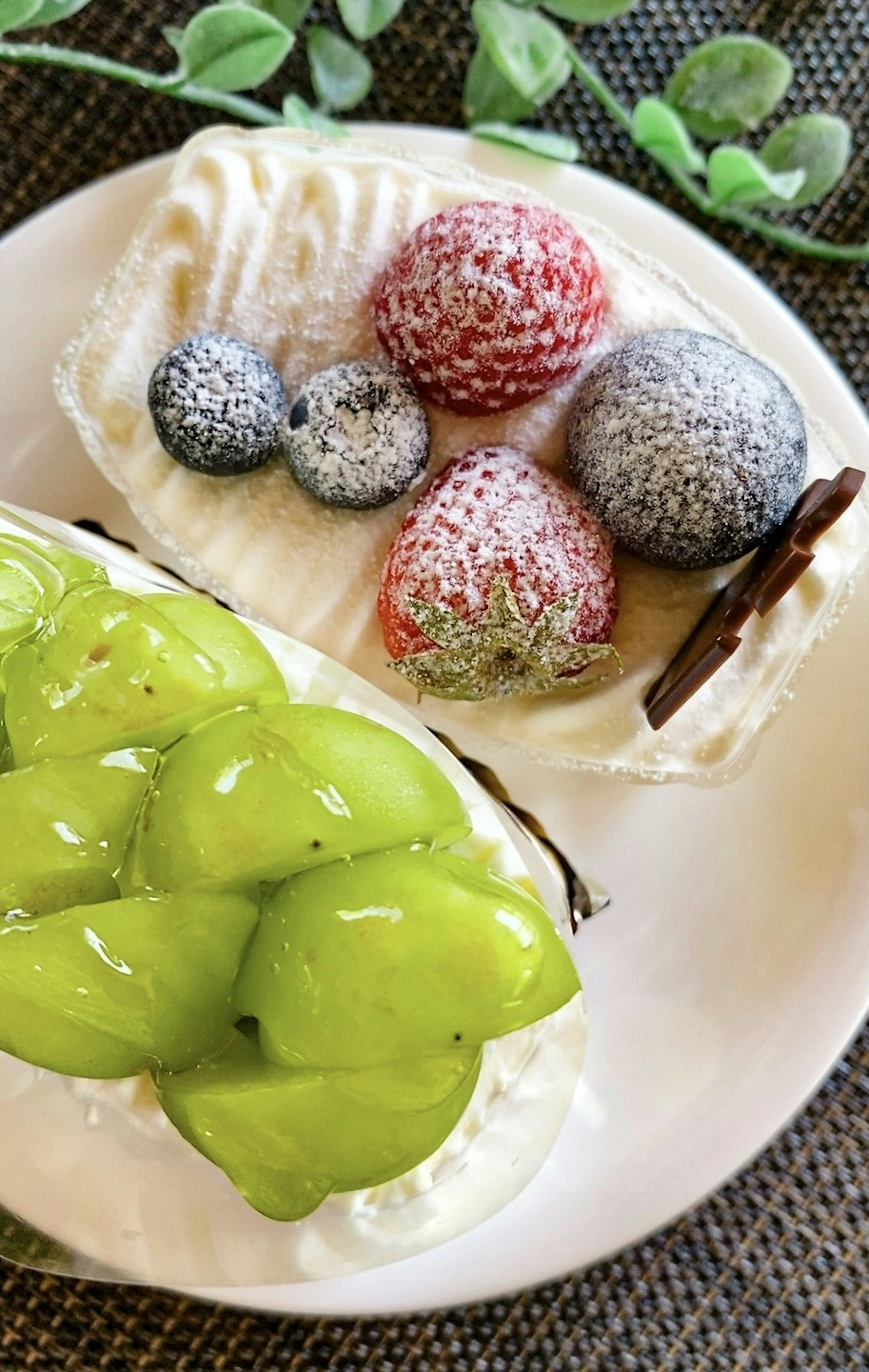 Rebanada de pastel de frutas cubierta de crema con bayas frescas y frutas verdes