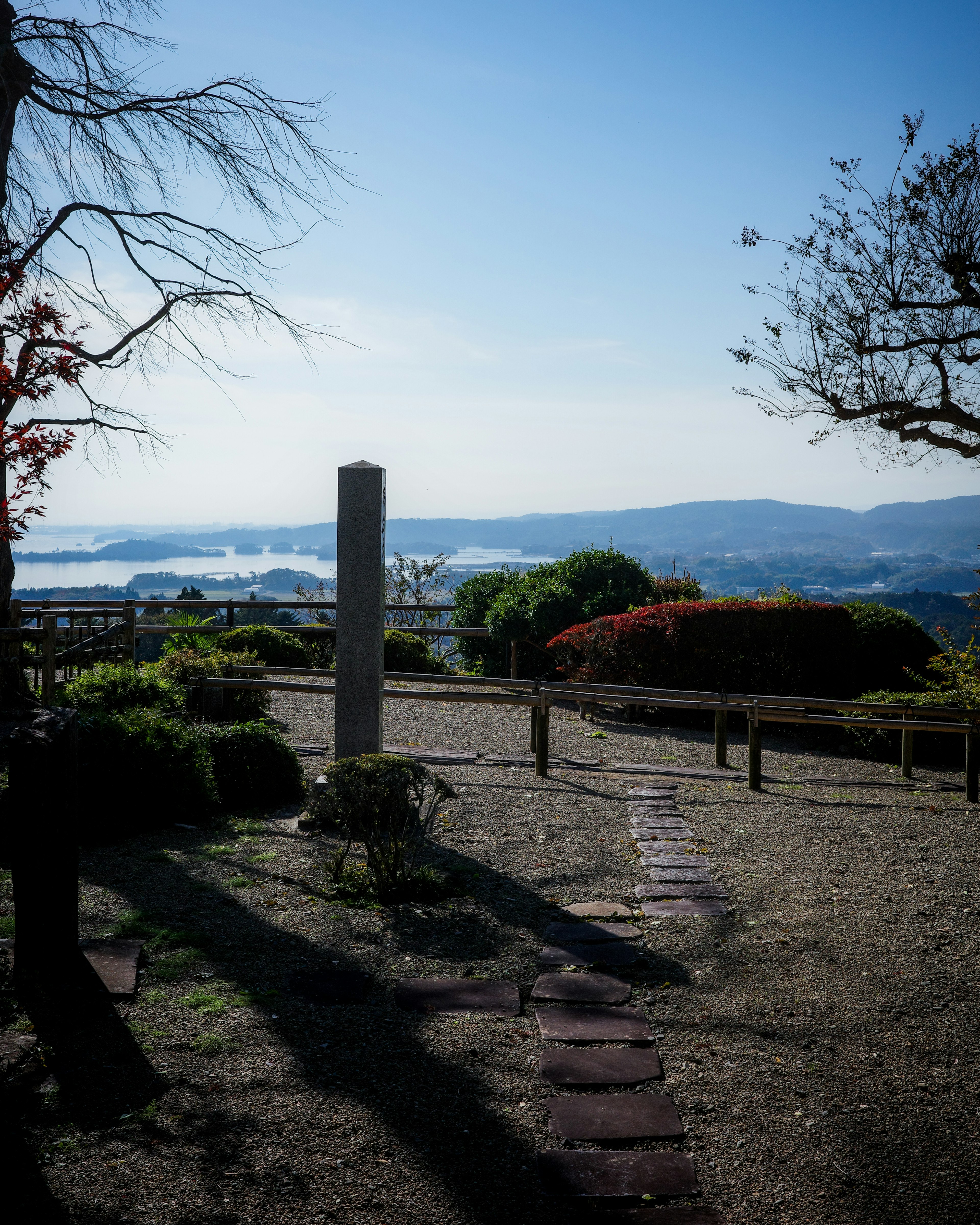 青い空と海を背景にした庭園の景色 石碑と小道が見える