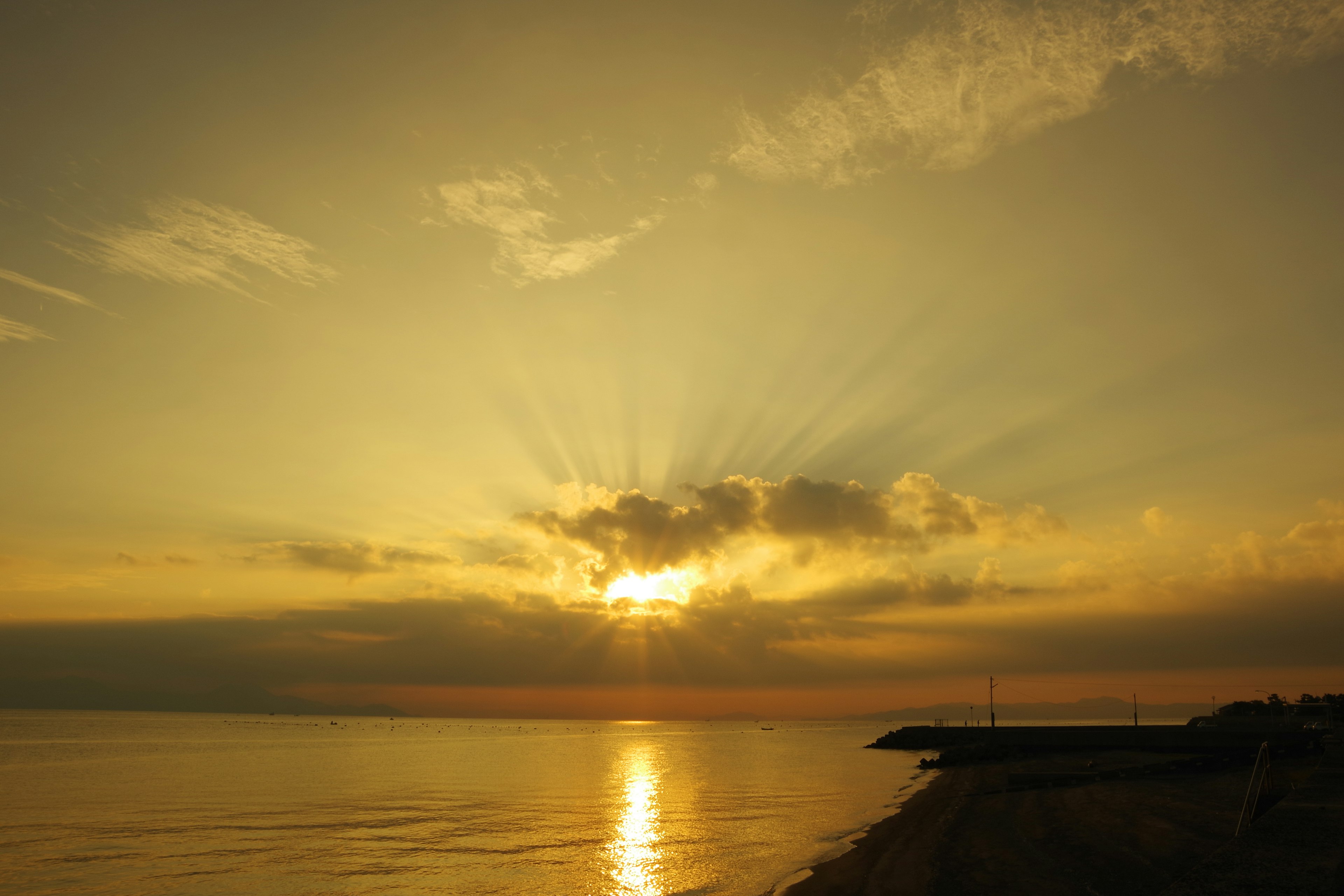 美丽的海景，夕阳透过云层照射