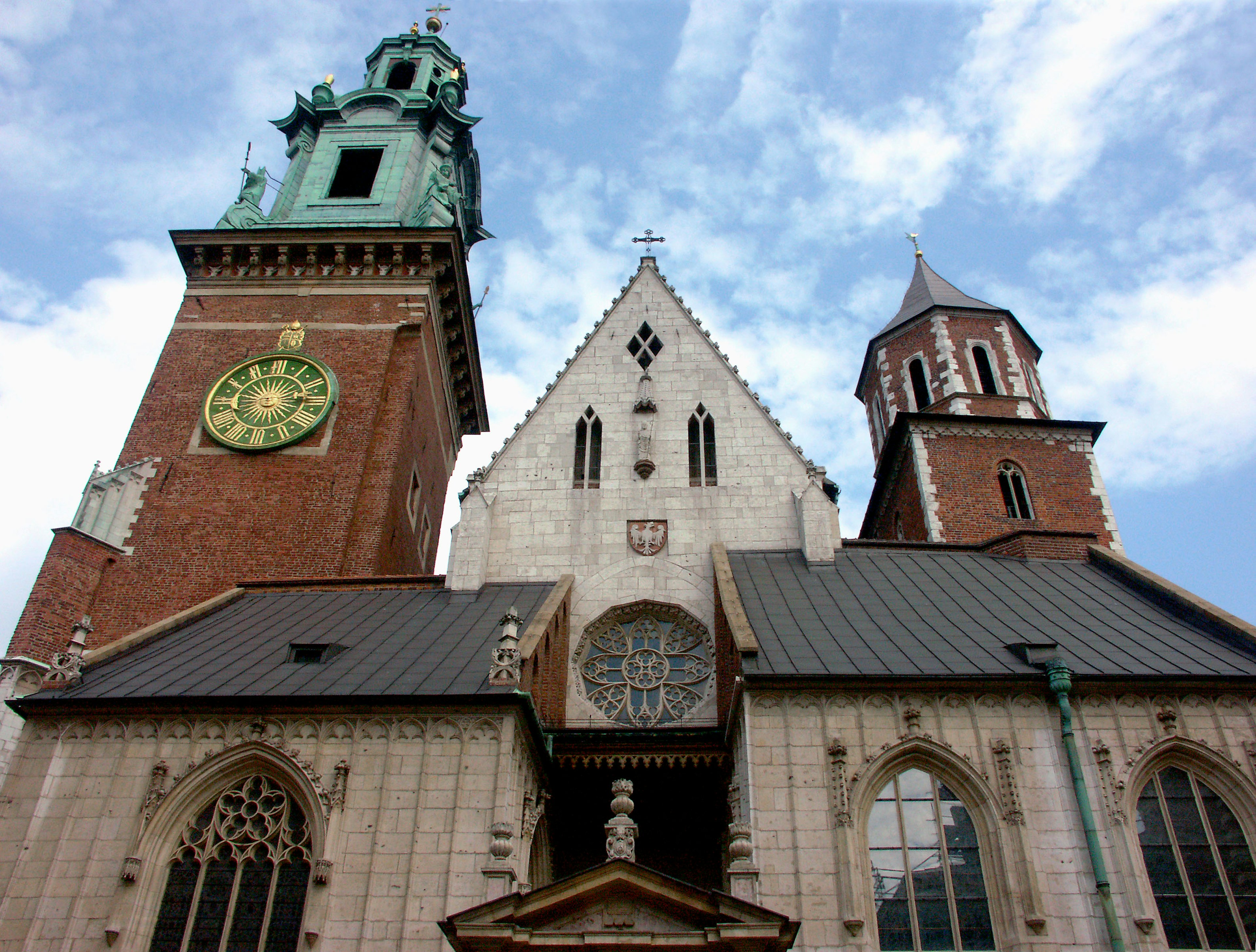 Blick auf die Marienbasilika in Krakau von unten mit hohen Türmen und kunstvollen Fenstern