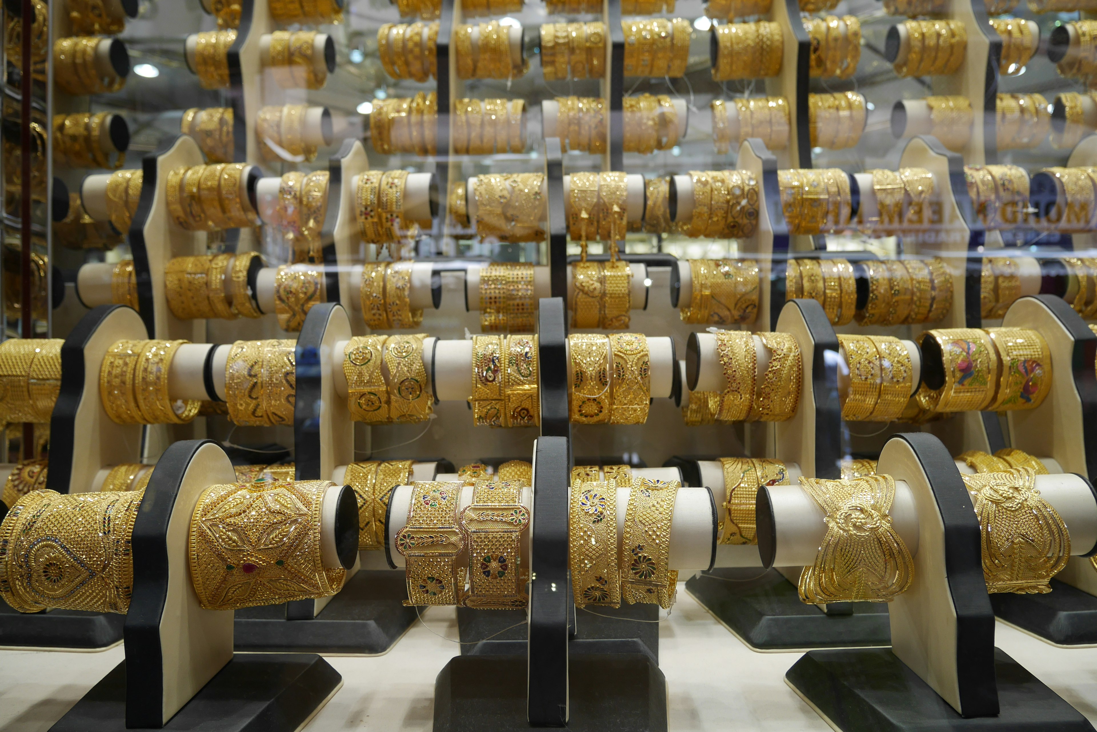 Display of intricately designed golden bracelets arranged in rows