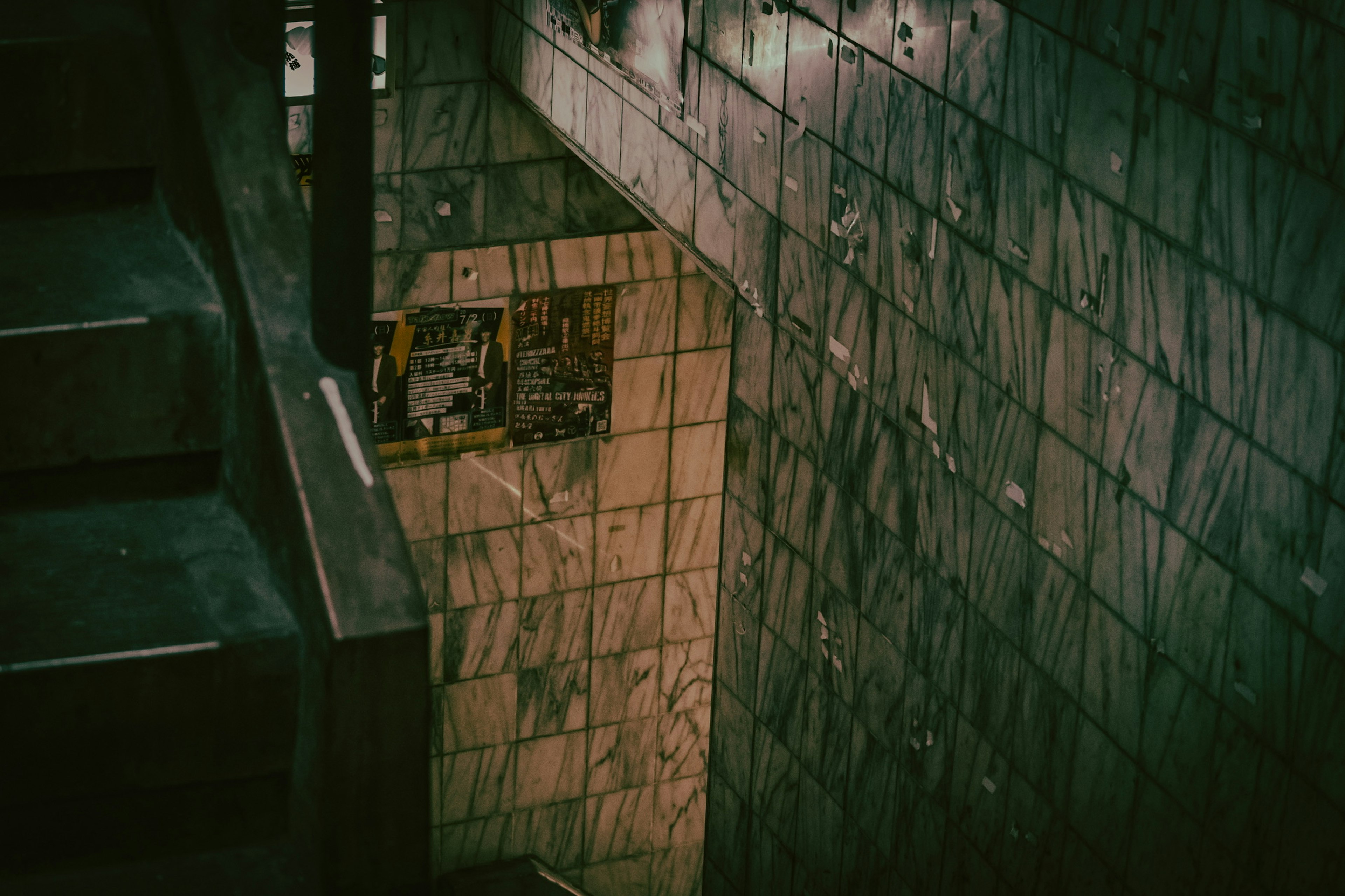 Image présentant un escalier sombre et un mur carrelé