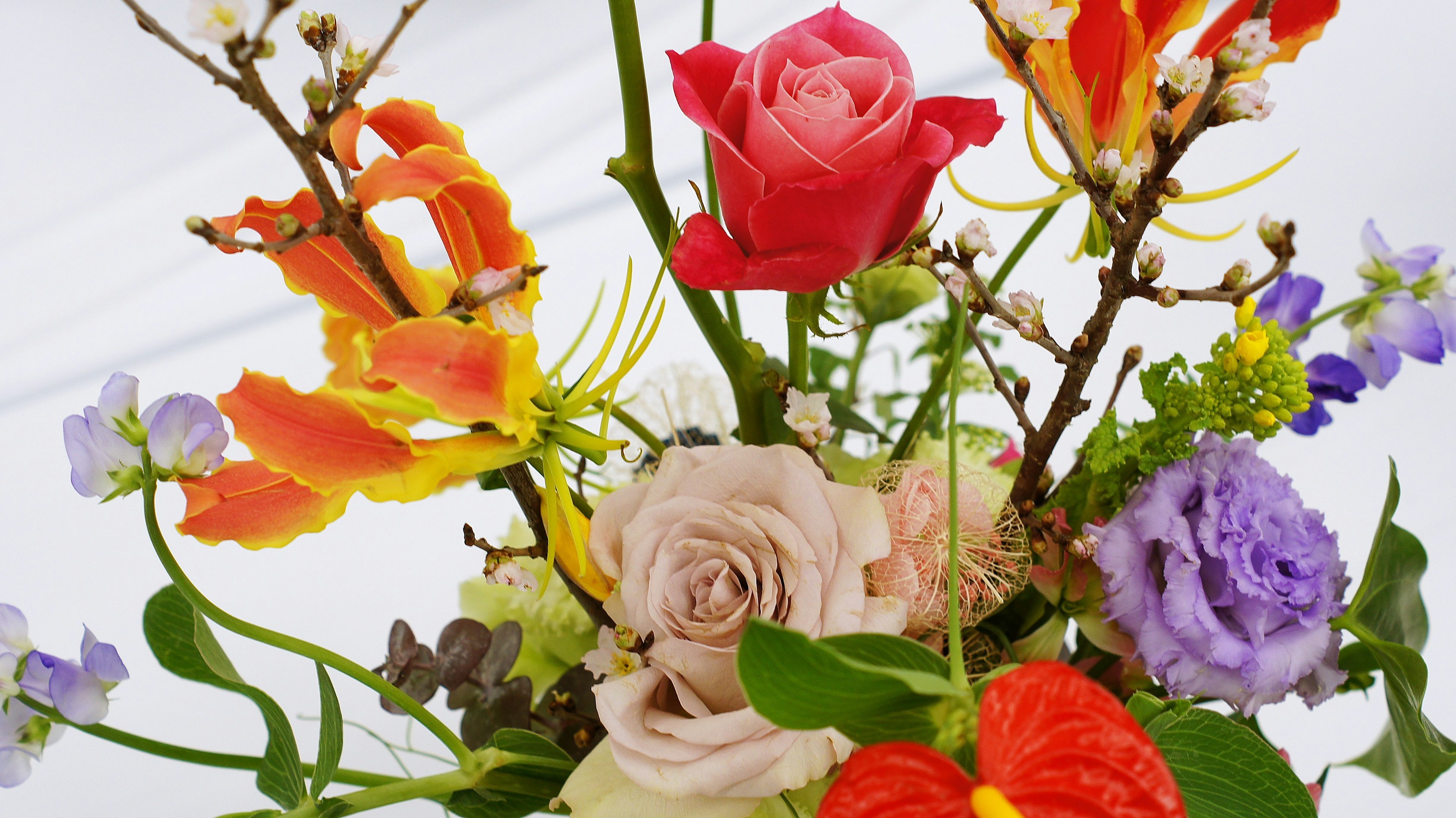 Bouquet coloré avec des roses rouges des fleurs orange et des fleurs violettes