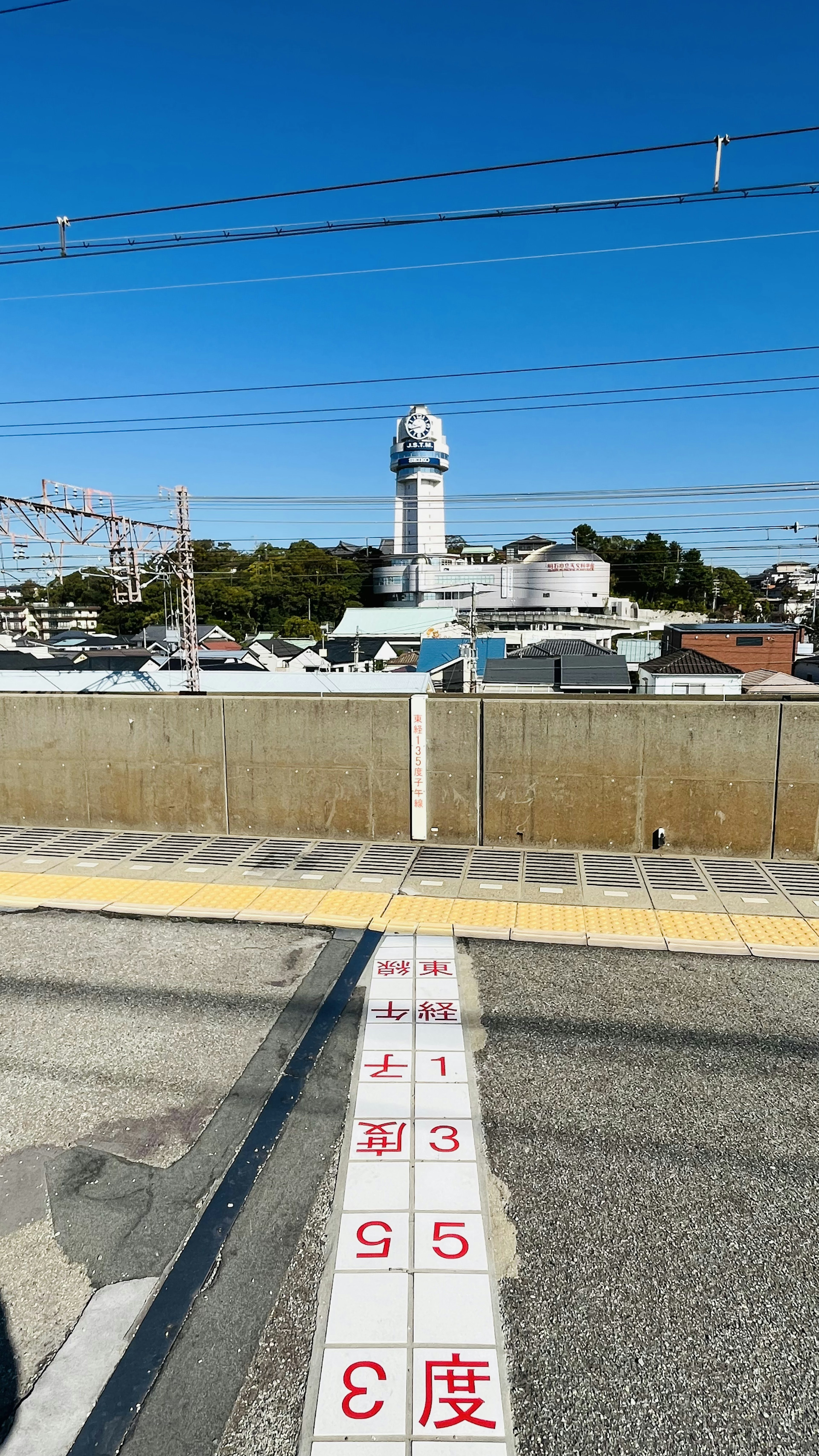 青空の下にある白い塔と鉄道の風景