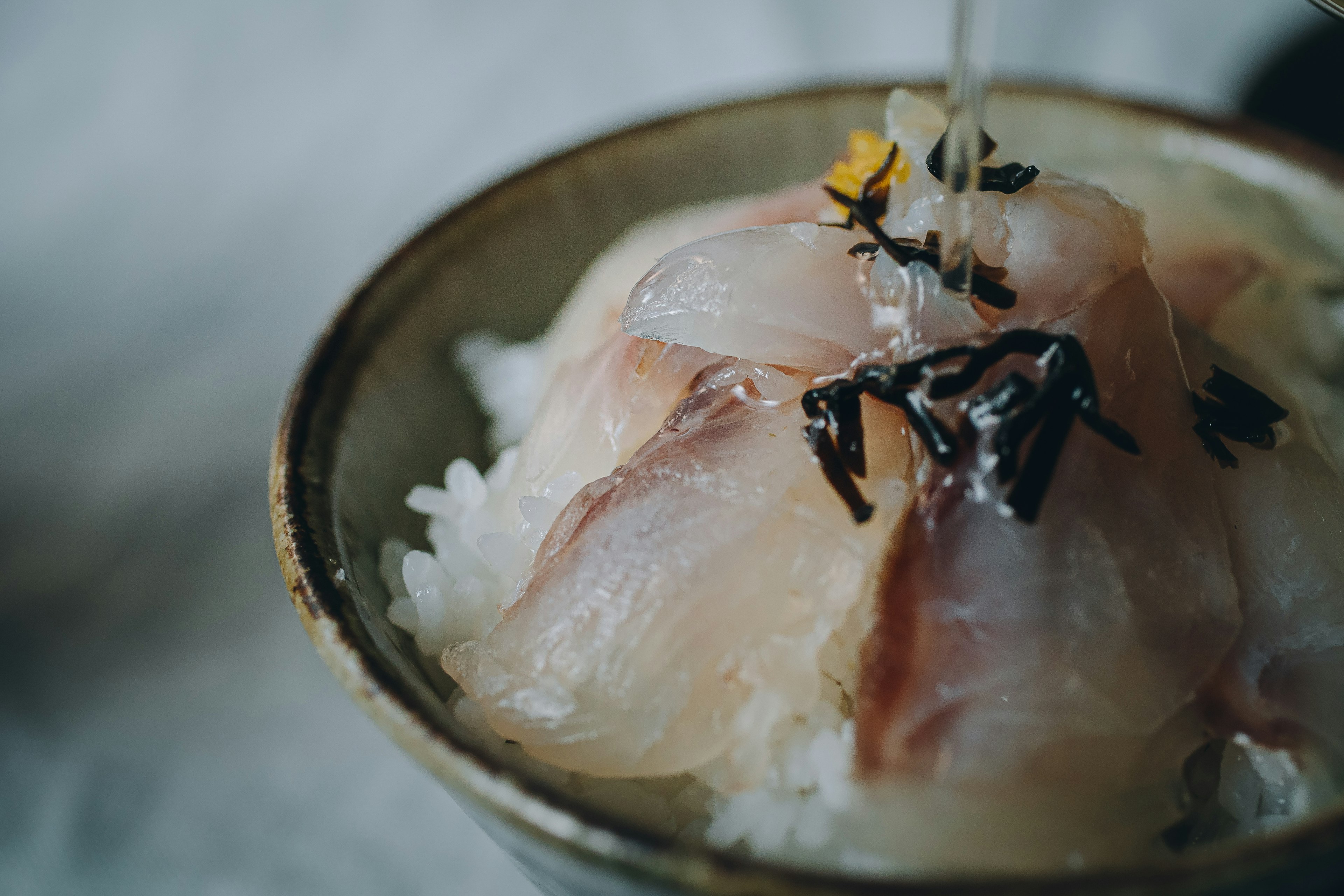 Bol de riz surmonté de sashimi frais et de garnitures colorées