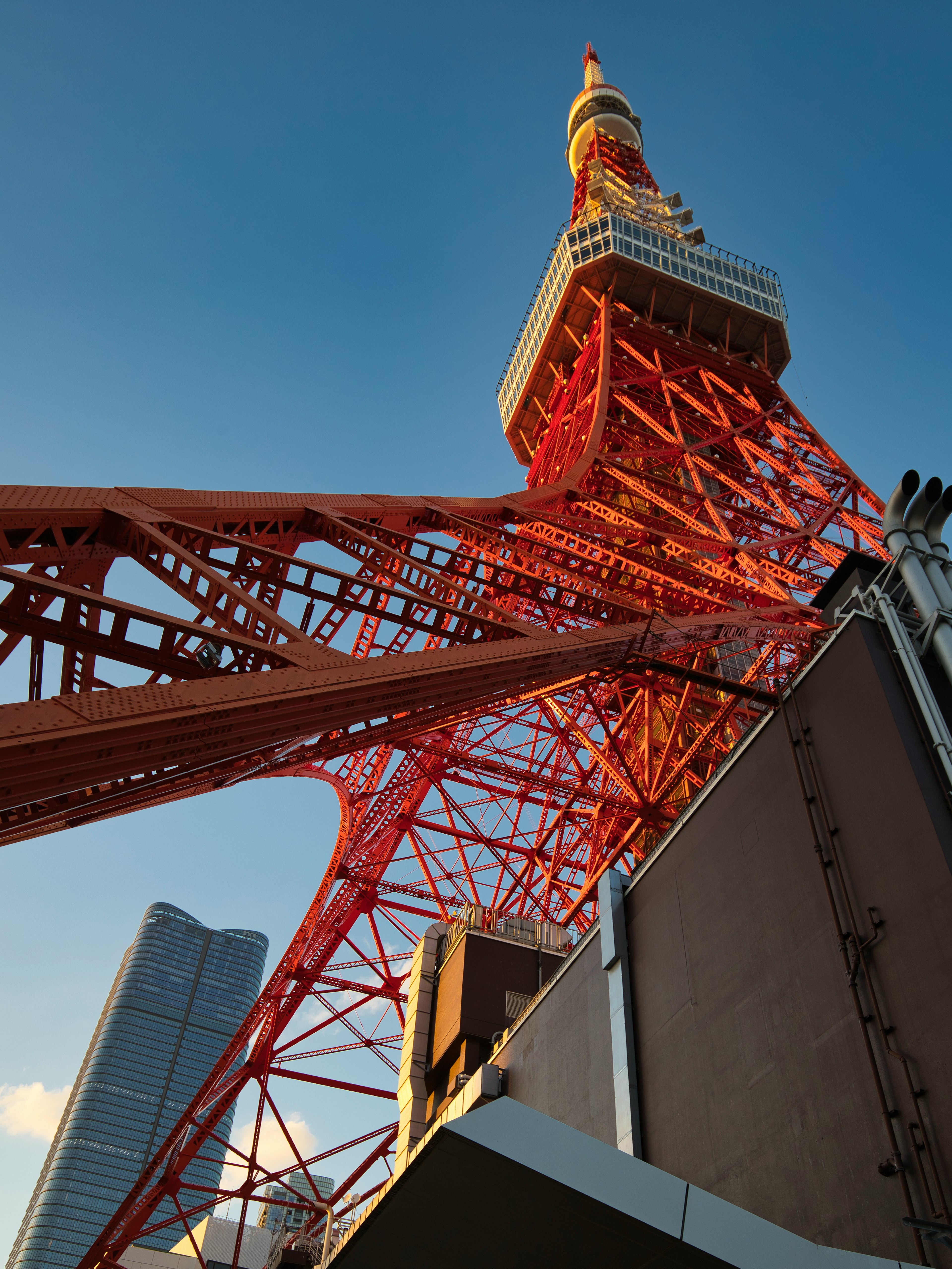 東京タワーの下から見上げた視点で赤い鉄骨構造と青空