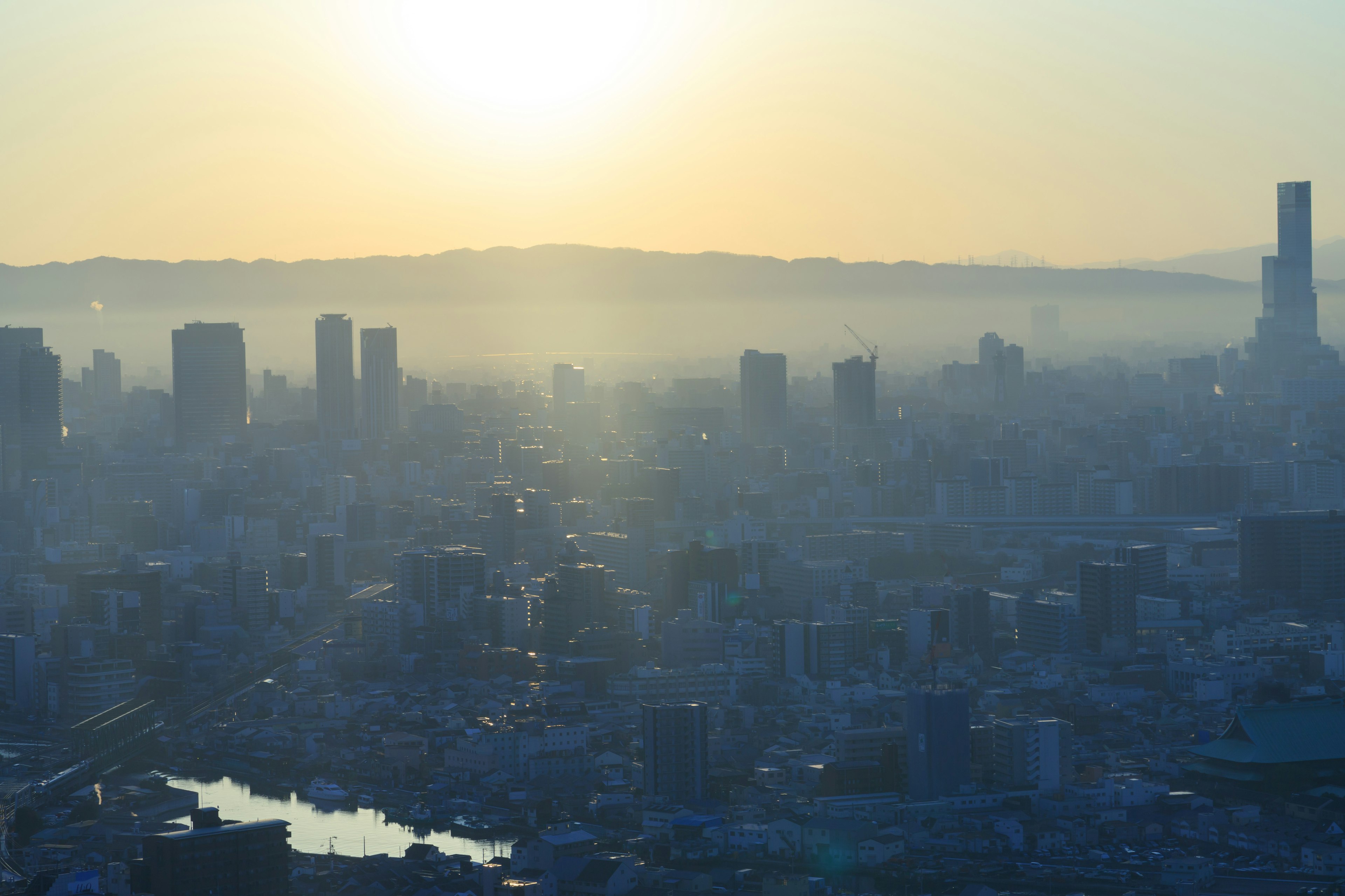 Paisaje urbano al atardecer con neblina y siluetas de edificios