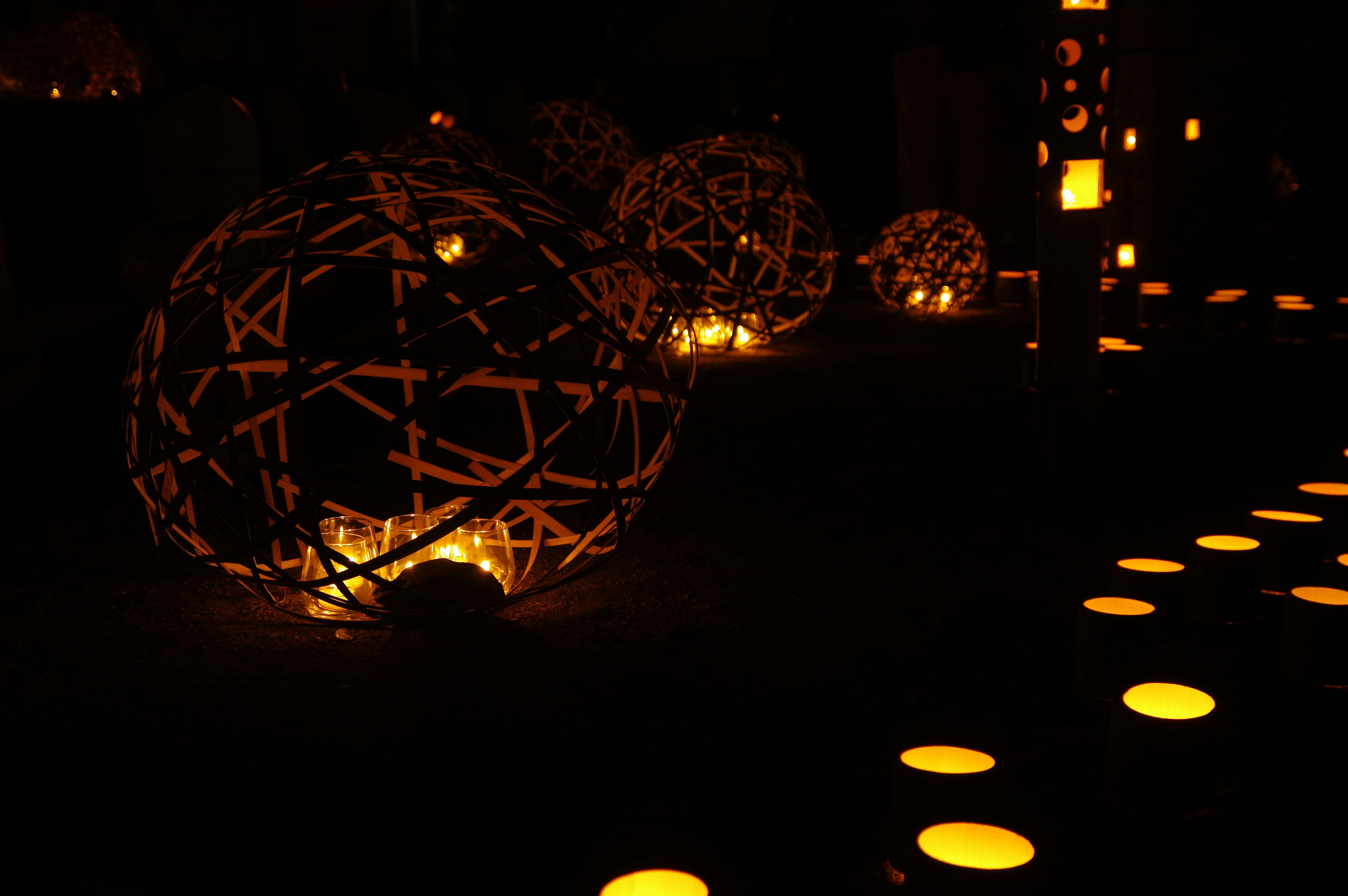 A mystical scene with glowing spherical lanterns and candle lights on a dark background