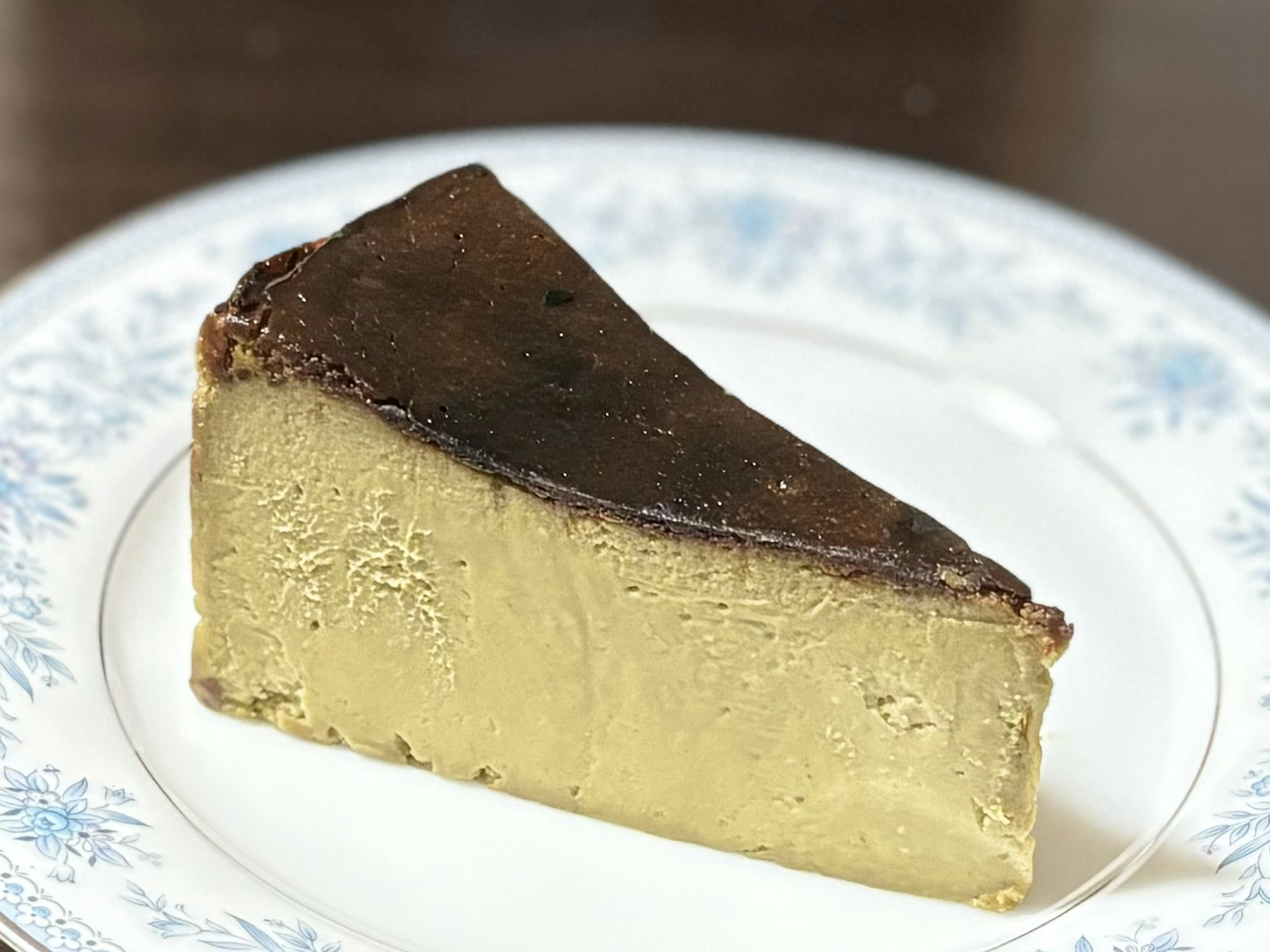 A slice of caramel-colored cheesecake on a white plate