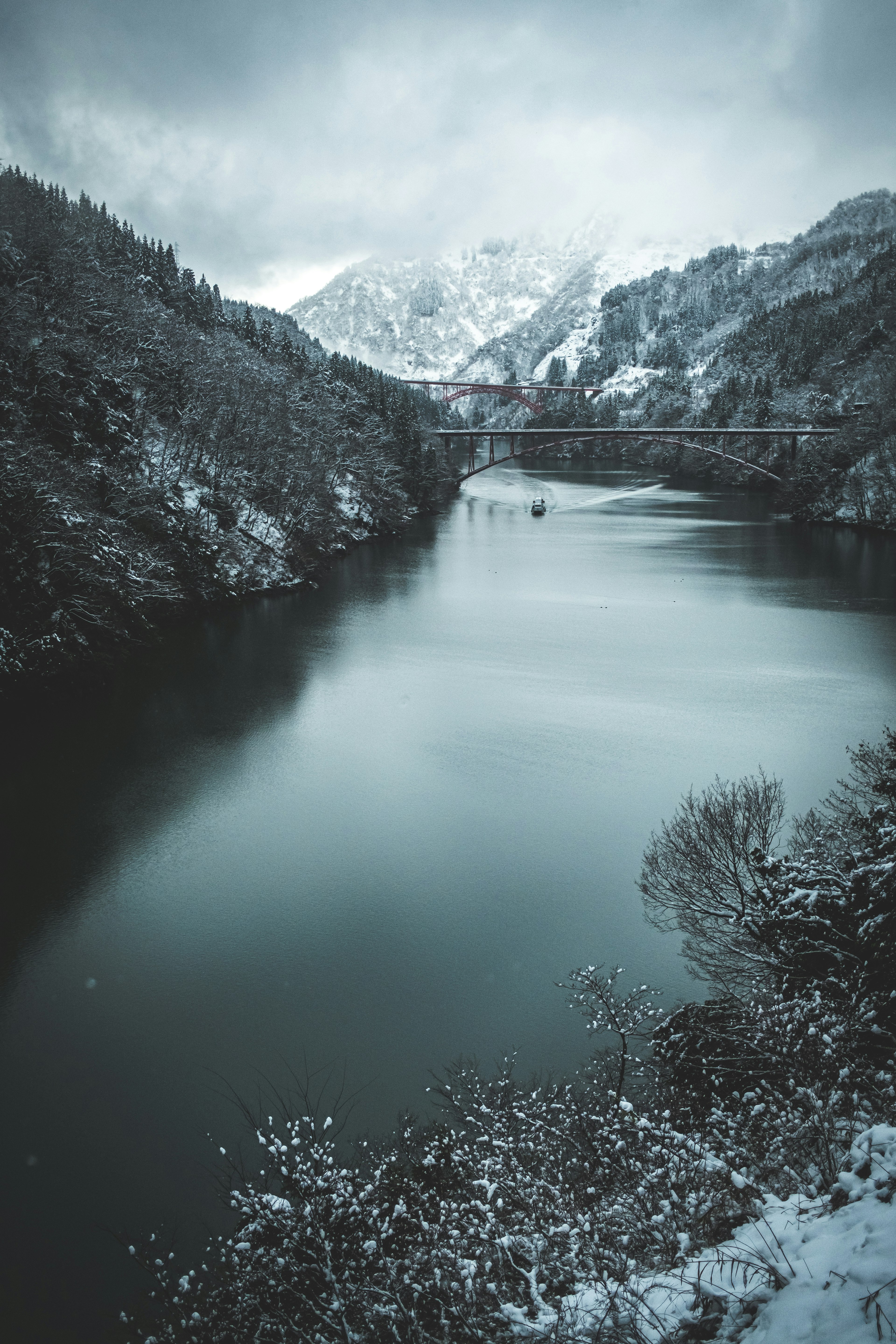 Winter landscape featuring snow-covered mountains and a calm lake