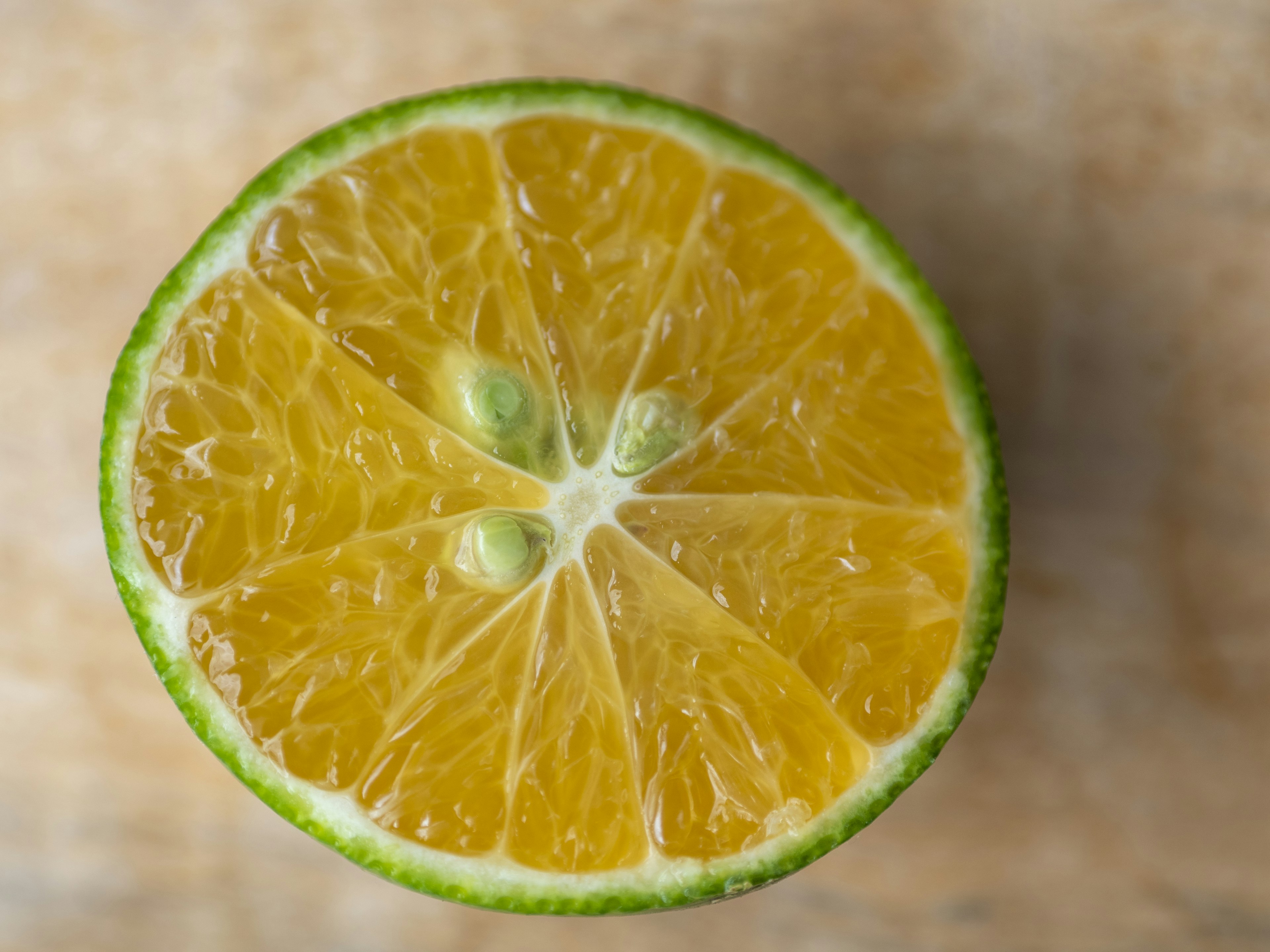 Image montrant un citron vert coupé avec une chair jaunâtre et une peau verte