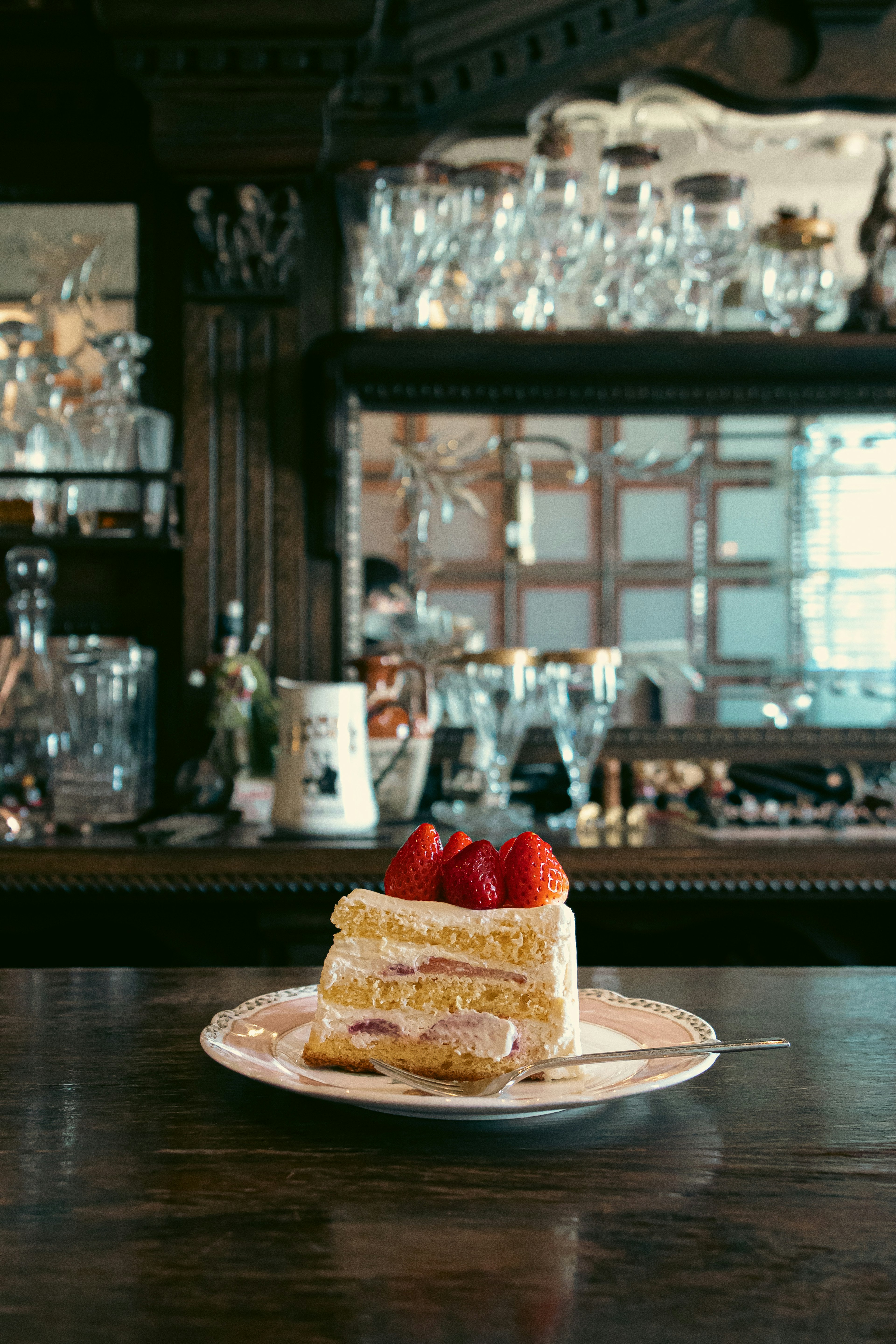 Pastel de crema con fresas en un plato en el mostrador del bar