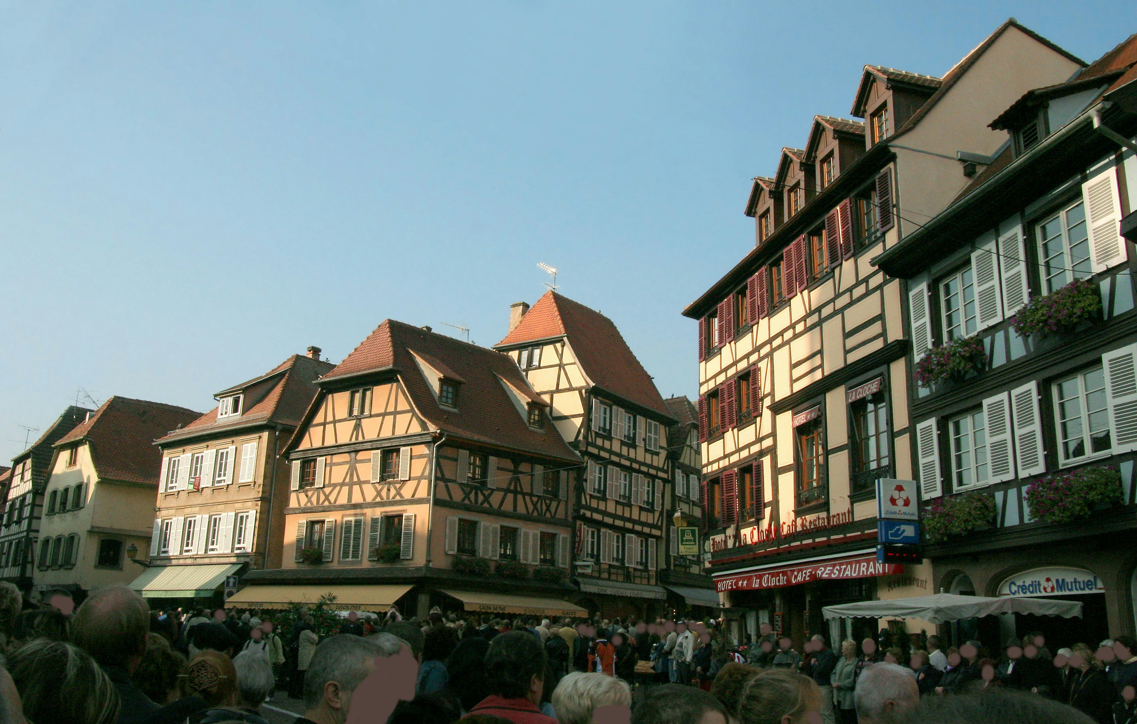 Maisons à colombages historiques bordant une rue sous un ciel bleu clair