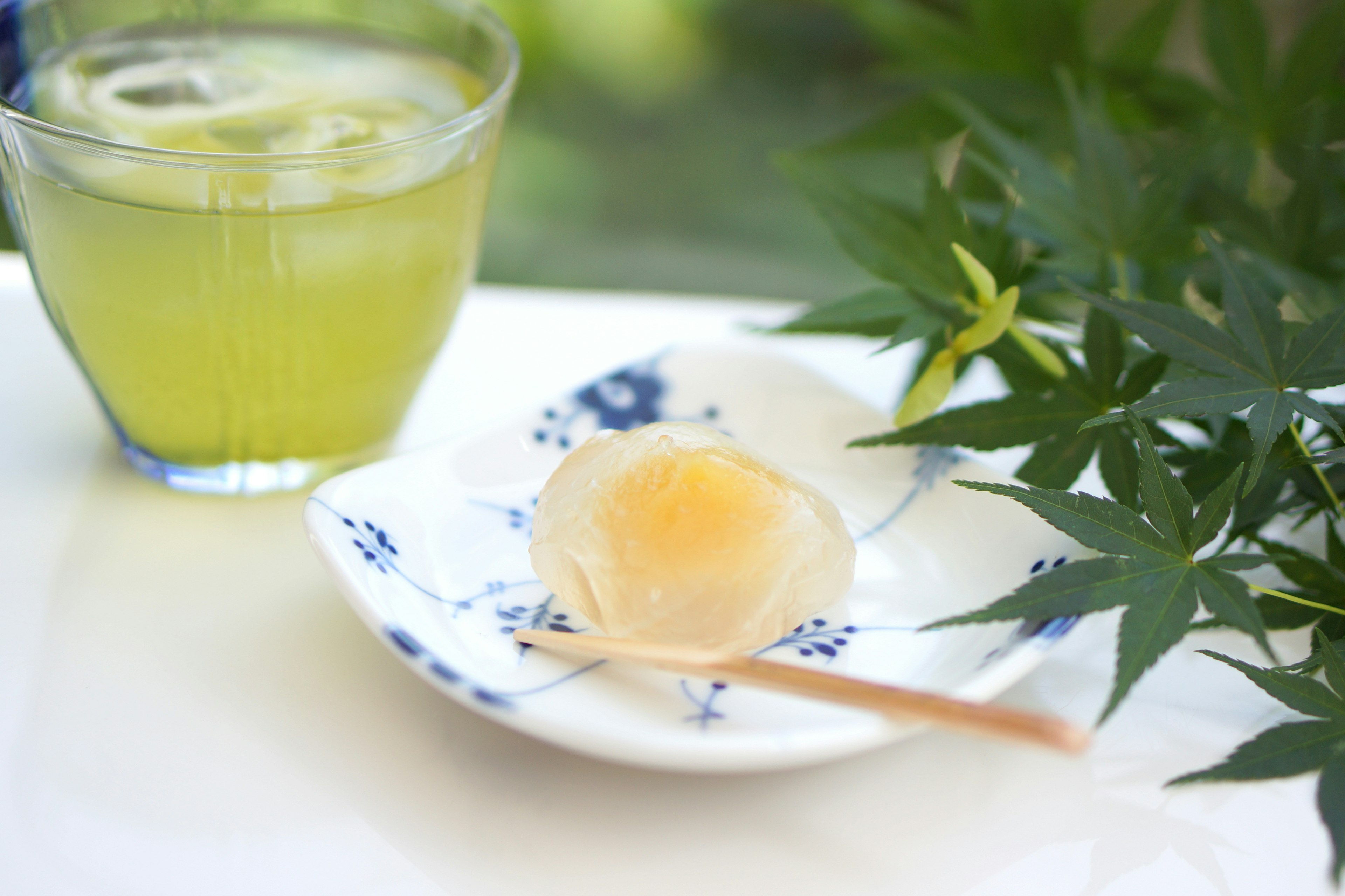 Una hermosa disposición de mesa con un postre translúcido y una bebida de té verde