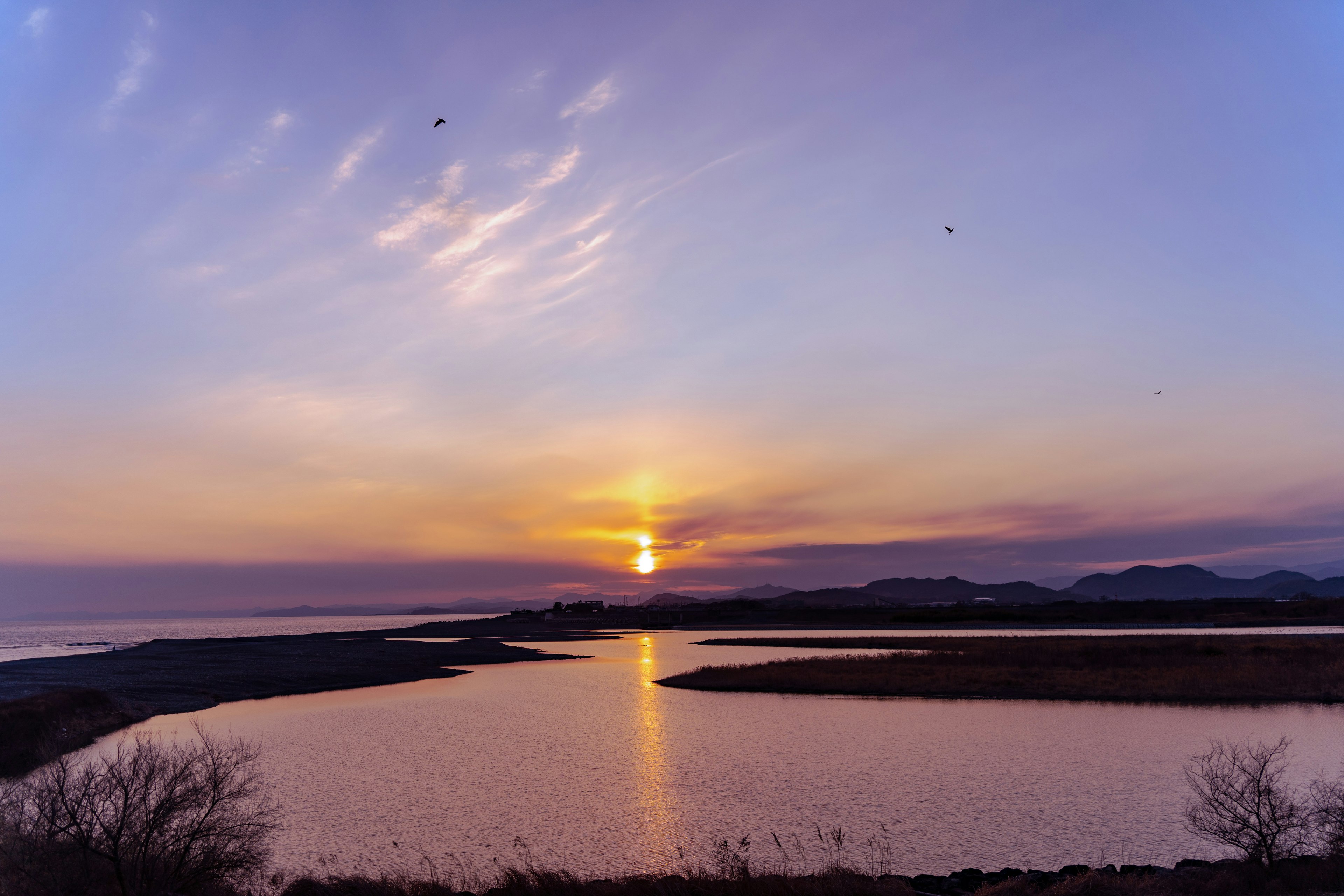 美しい夕日が海に沈む風景 水面に反射するオレンジと紫の色合い