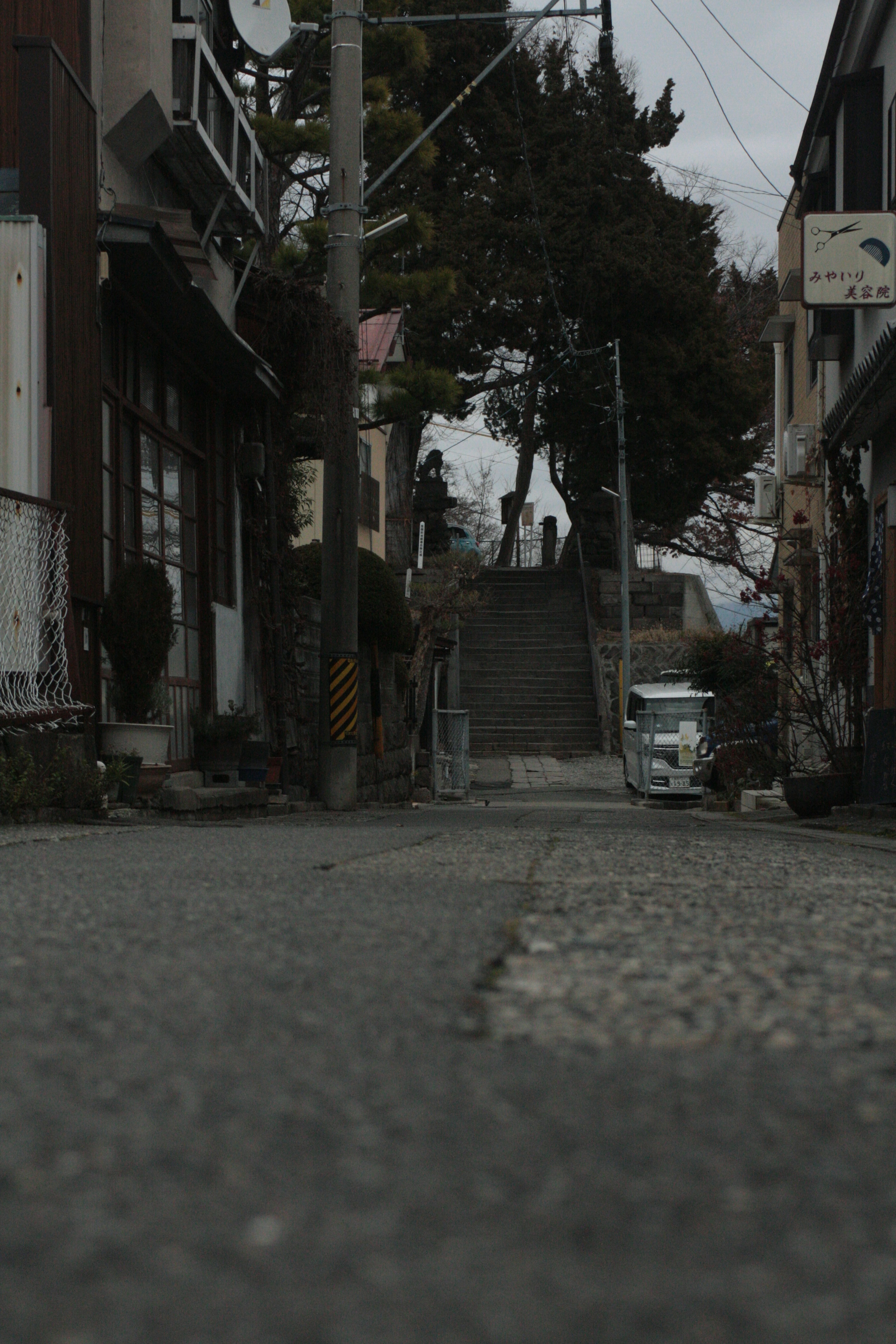 Narrow street lined with buildings and a staircase in the background