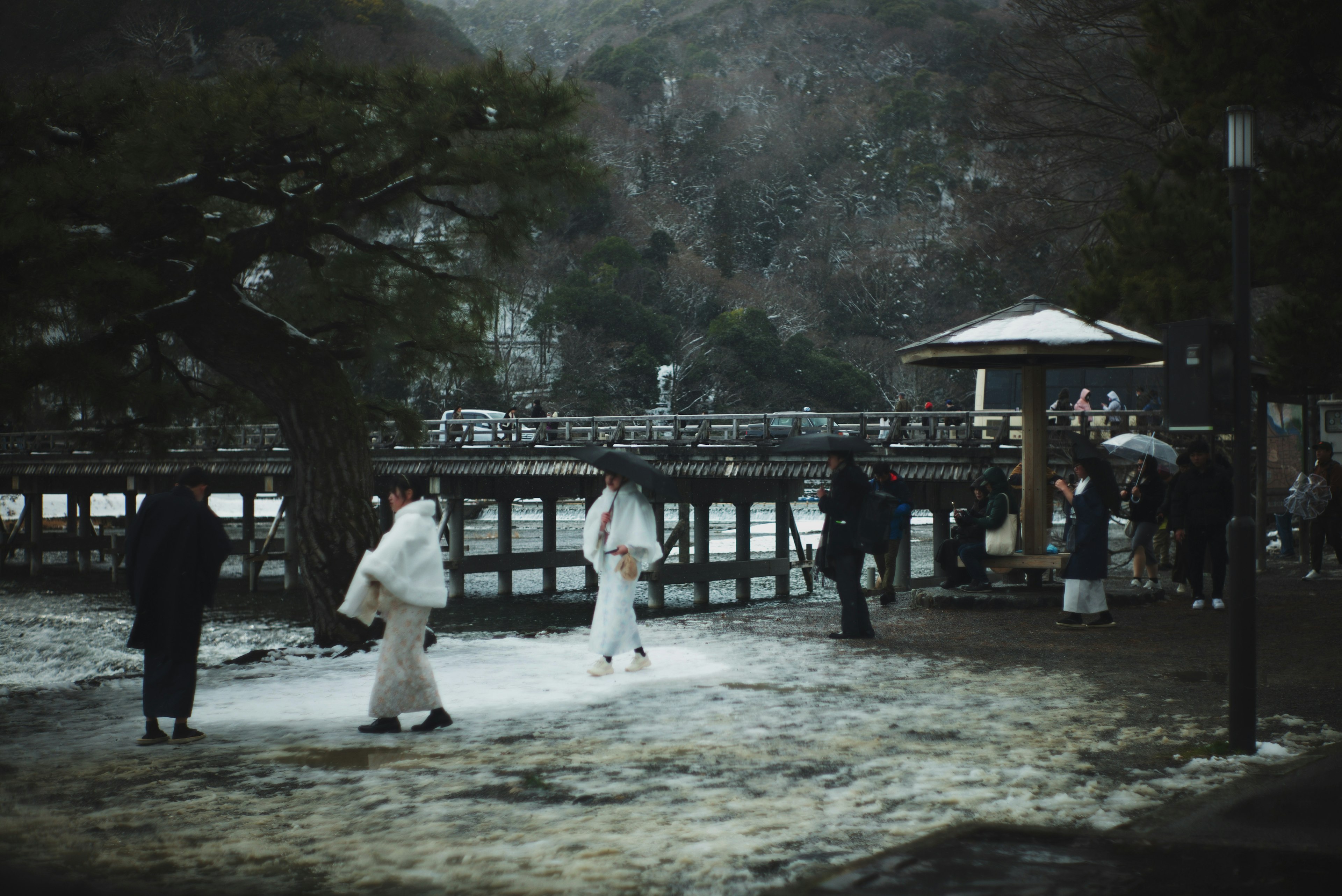 People in white clothing walking in the snow with a scenic background